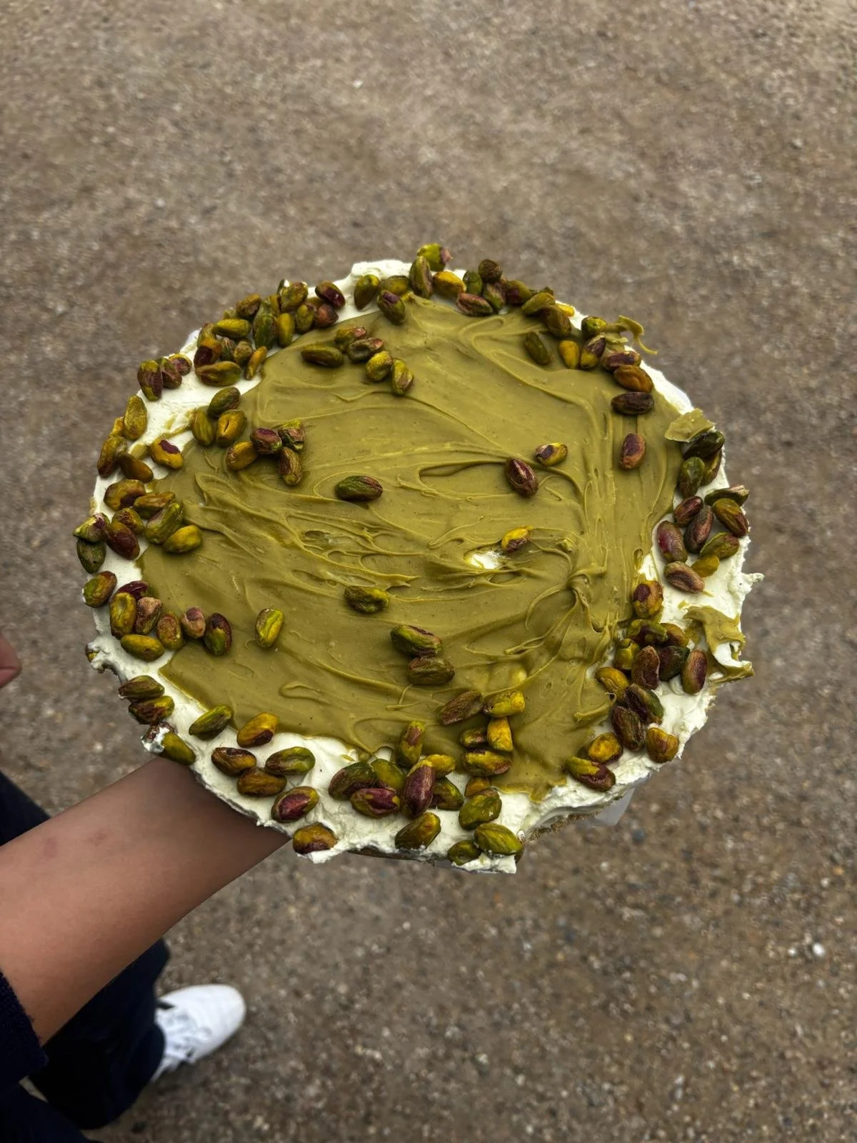 Tarte avec un glaçage vert et des pistaches en décoration.