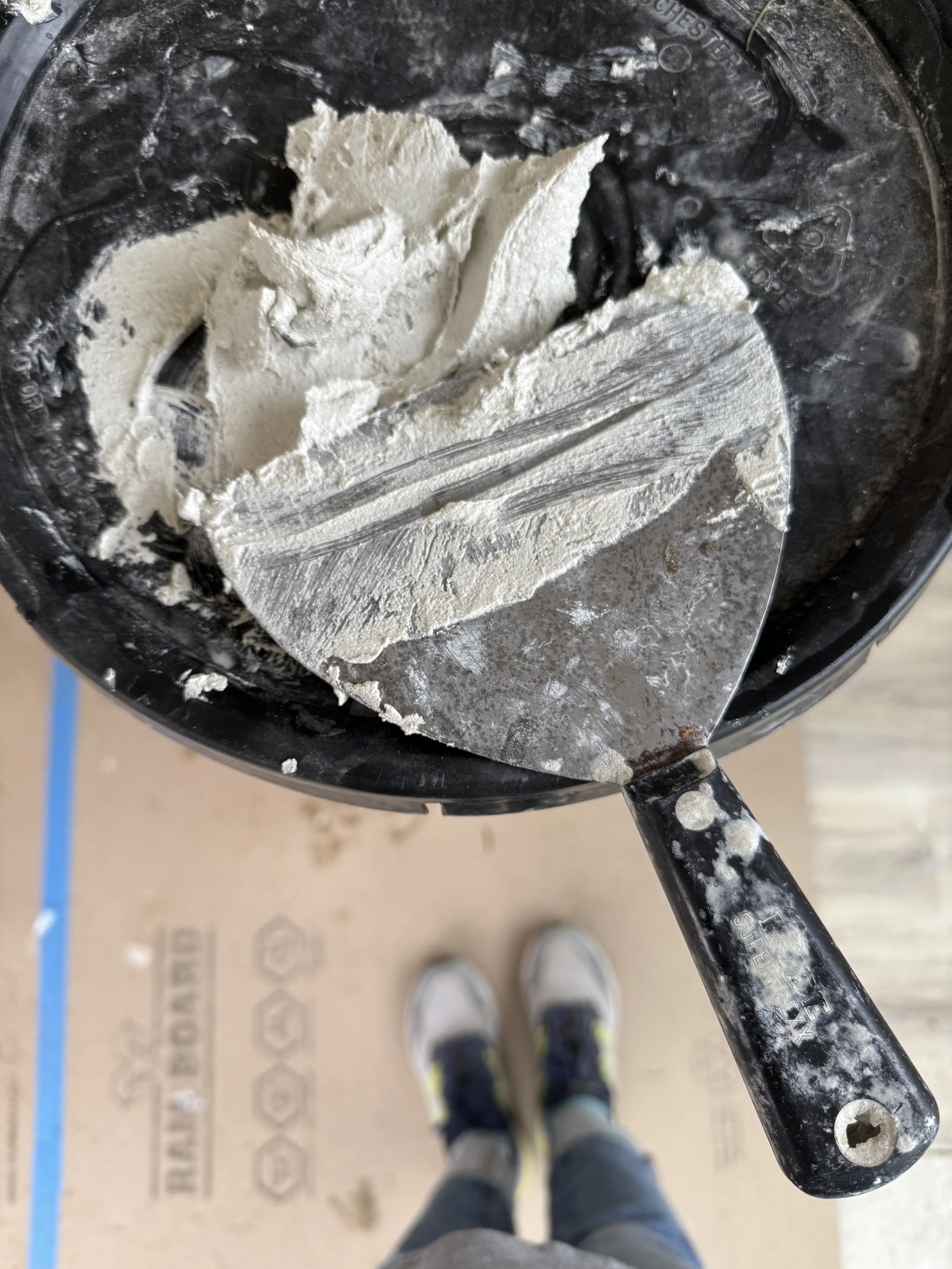 Spackle knife and mud on construction bucket