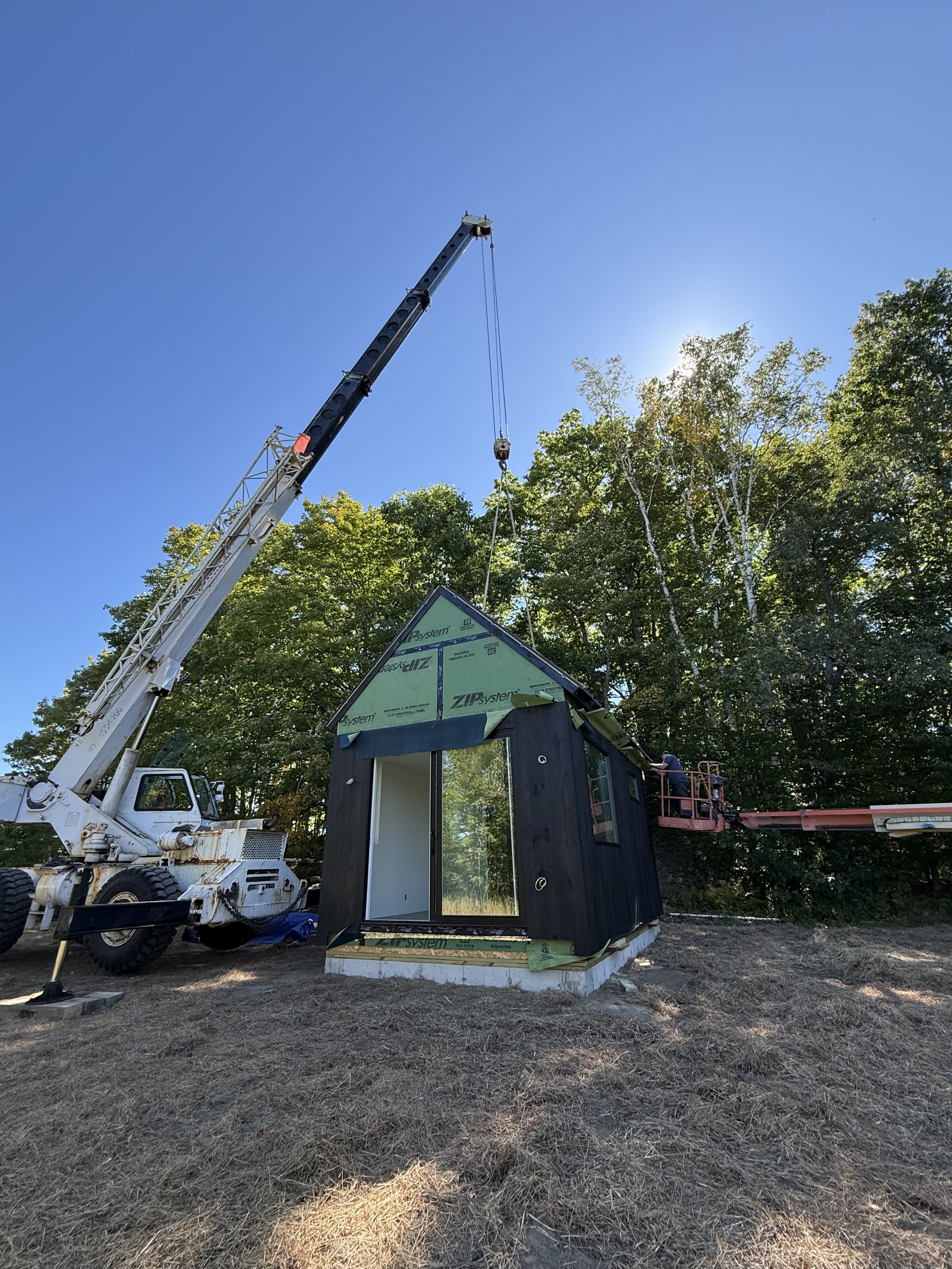 A crane installing a modern prefab cabin