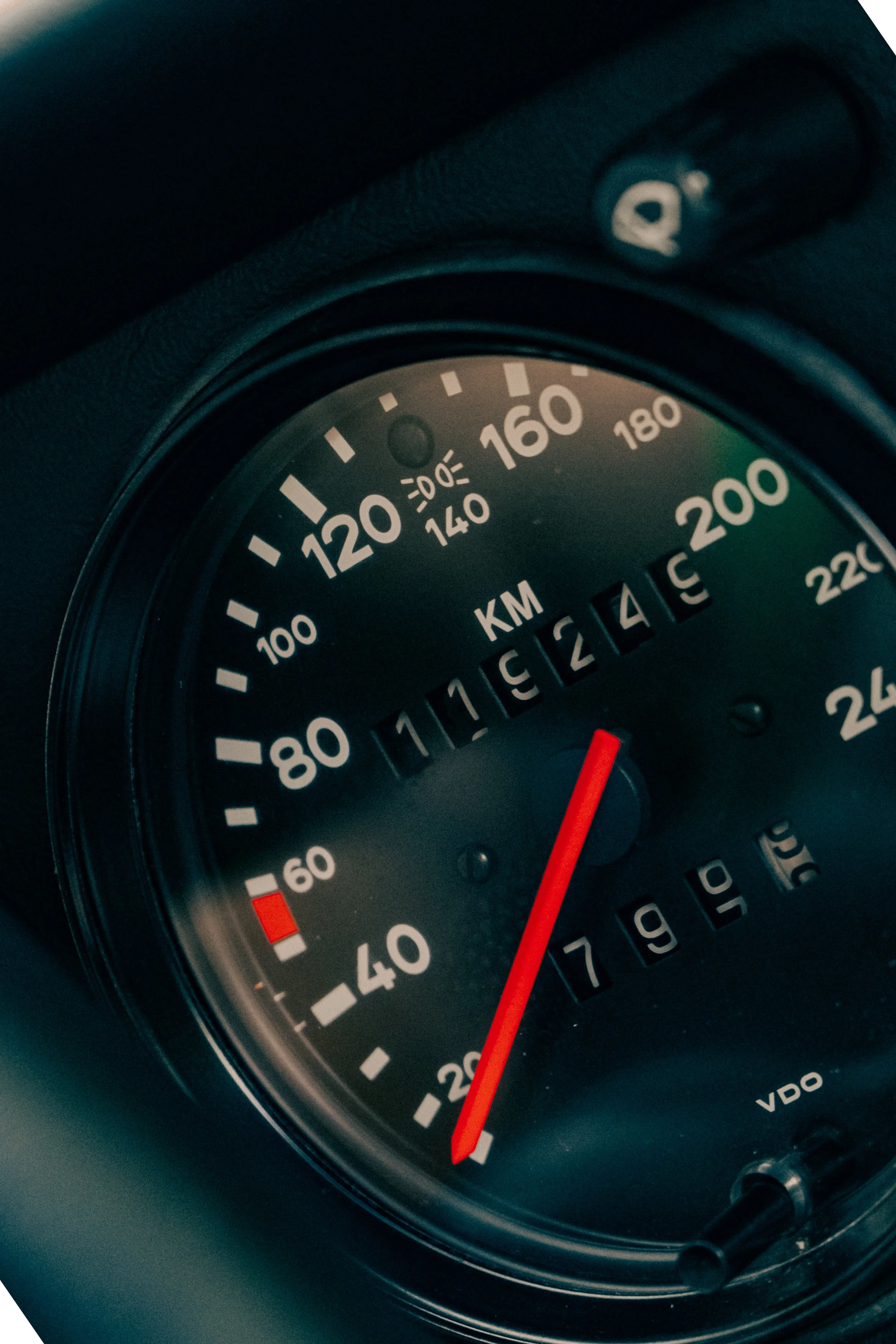 Close-up of a car's speedometer showing a speed of approximately 160 km/h, with the needle pointing just past 160.