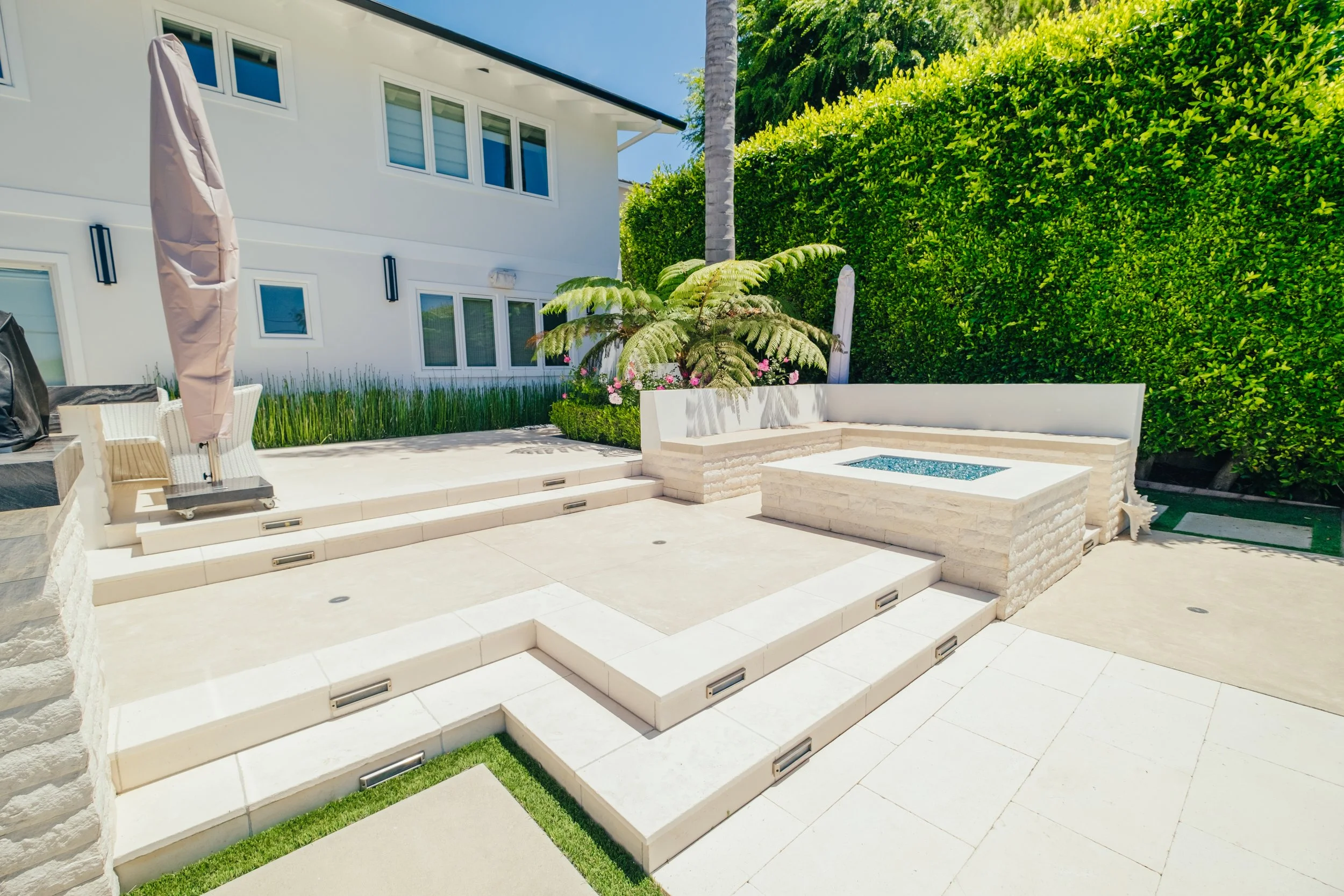 Custom fire pit seating area beside a backyard pool by Rosewood Landscape in Rancho Palos Verdes, California