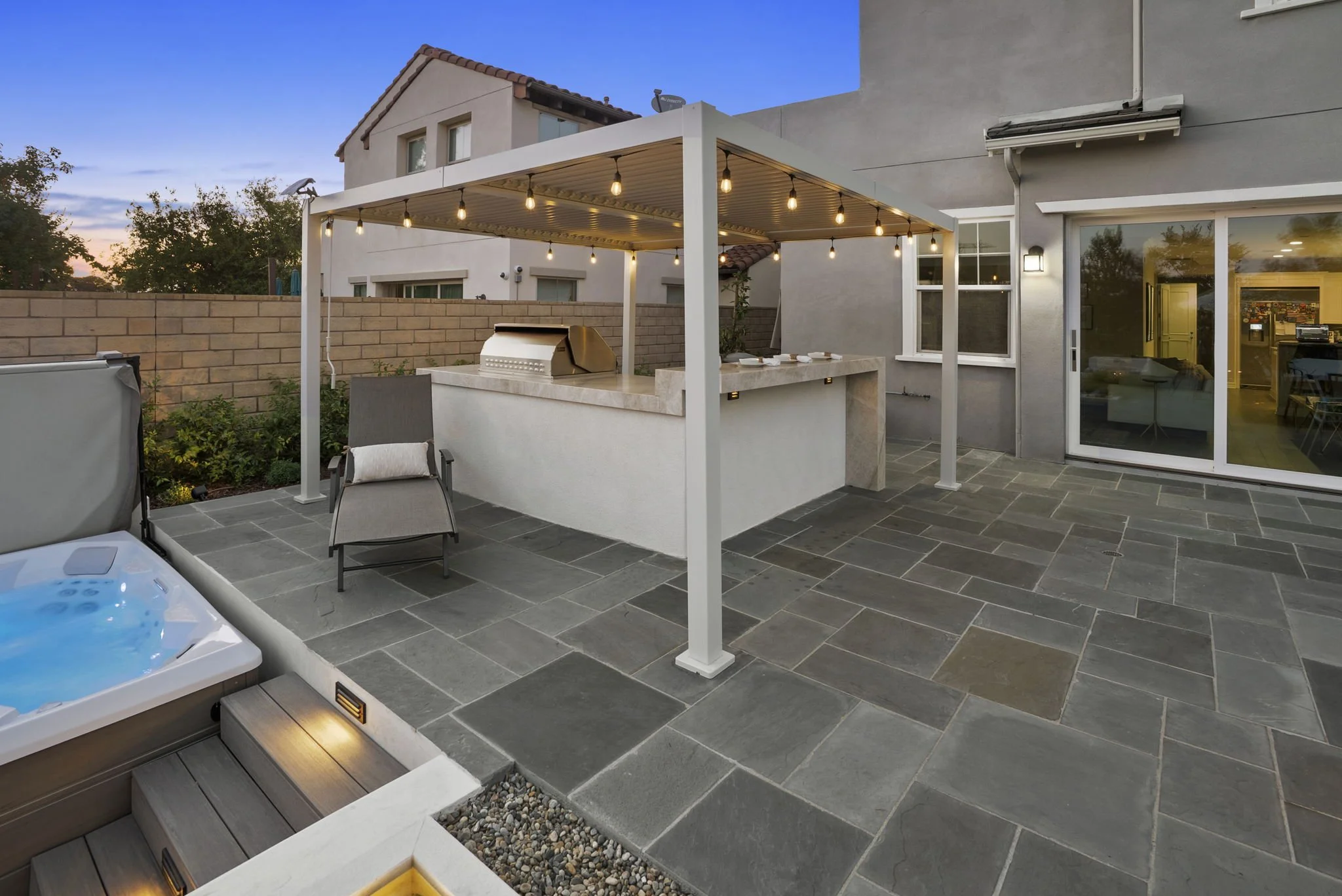 Custom hardscape, outdoor kitchen, pergola and patio construction by Rosewood Landscape