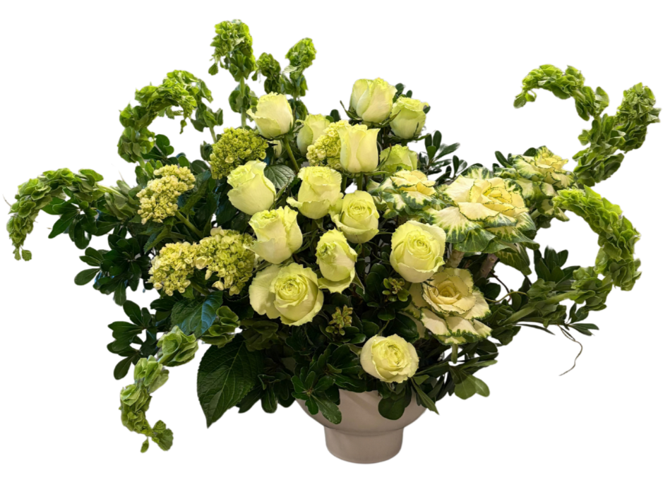 A flower arrangement in a white vase featuring white roses, green hydrangeas, and variegated leaves.