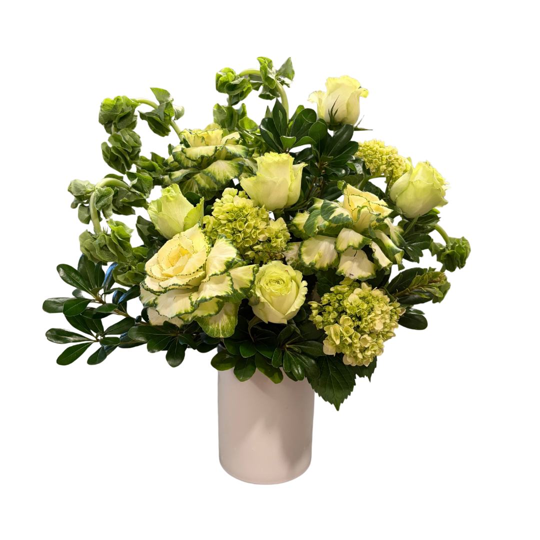 A white vase holding a bouquet of pale yellow and creamy white roses, green hydrangeas, and various green leafy foliage.