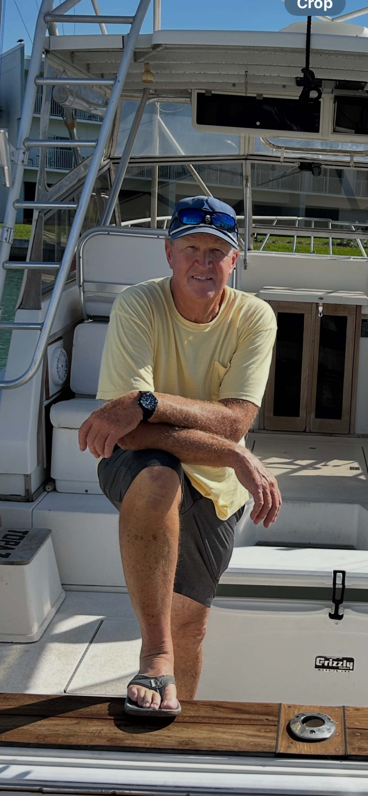 Captain Kenny kneeling aboard Southern Grin, his private fishing charter boat in Tierra Verde, Florida.