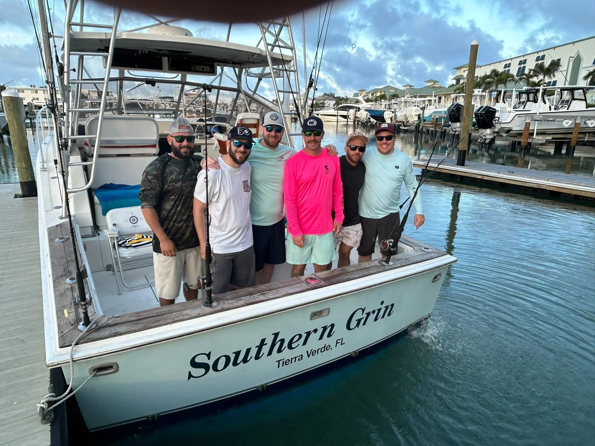 Group of six guests posing aboard Southern Grin while docked at a marina in Tierra Verde, Florida.