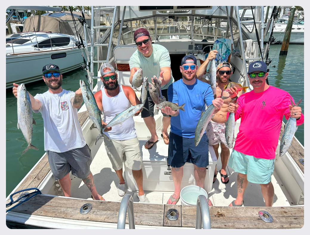Group of friends displaying their catches aboard Southern Grin after a fishing adventure.