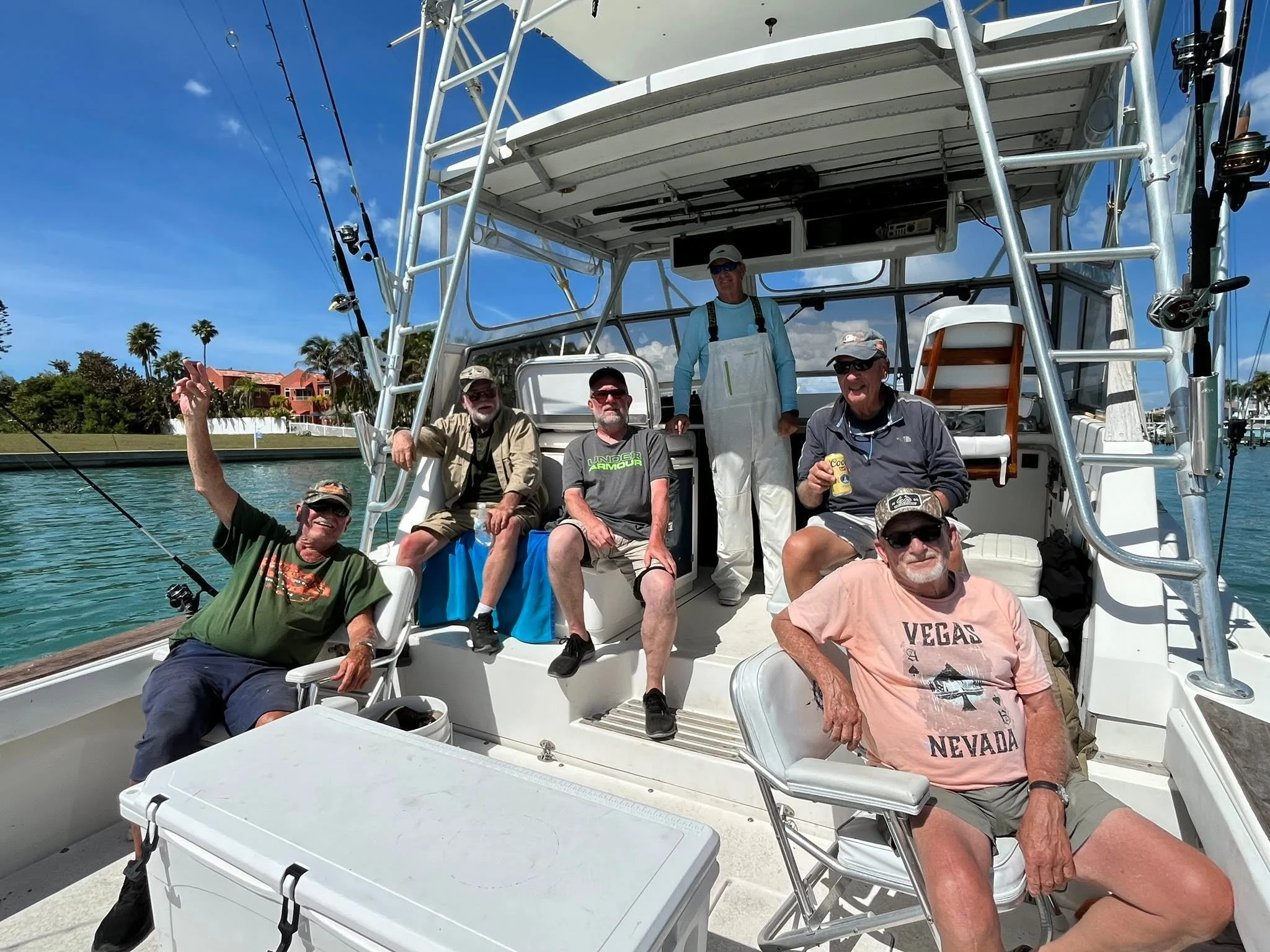 Group of six guests relaxing and smiling aboard Southern Grin while the fishing boat is on the water.