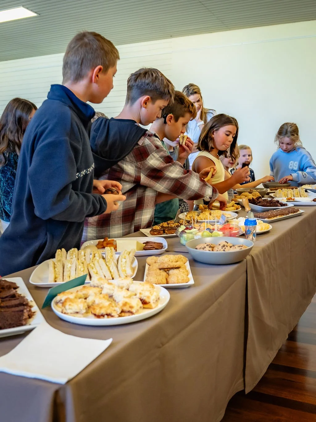 Children and adults serving food at a shared St Philips meal