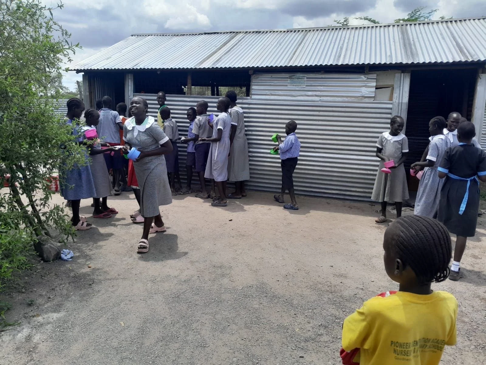 Pupils with bowls outside St Philip Primary School in Kalobeyei, waiting for lunch.