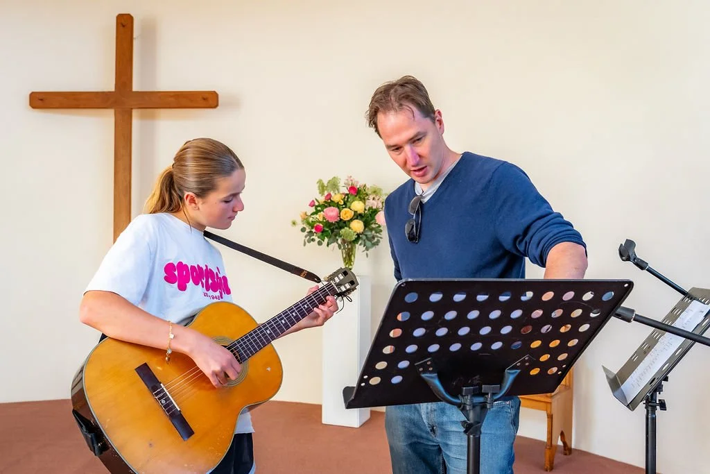 Young people singing and playing keyboard during a rehearsal at St Philip’s.
