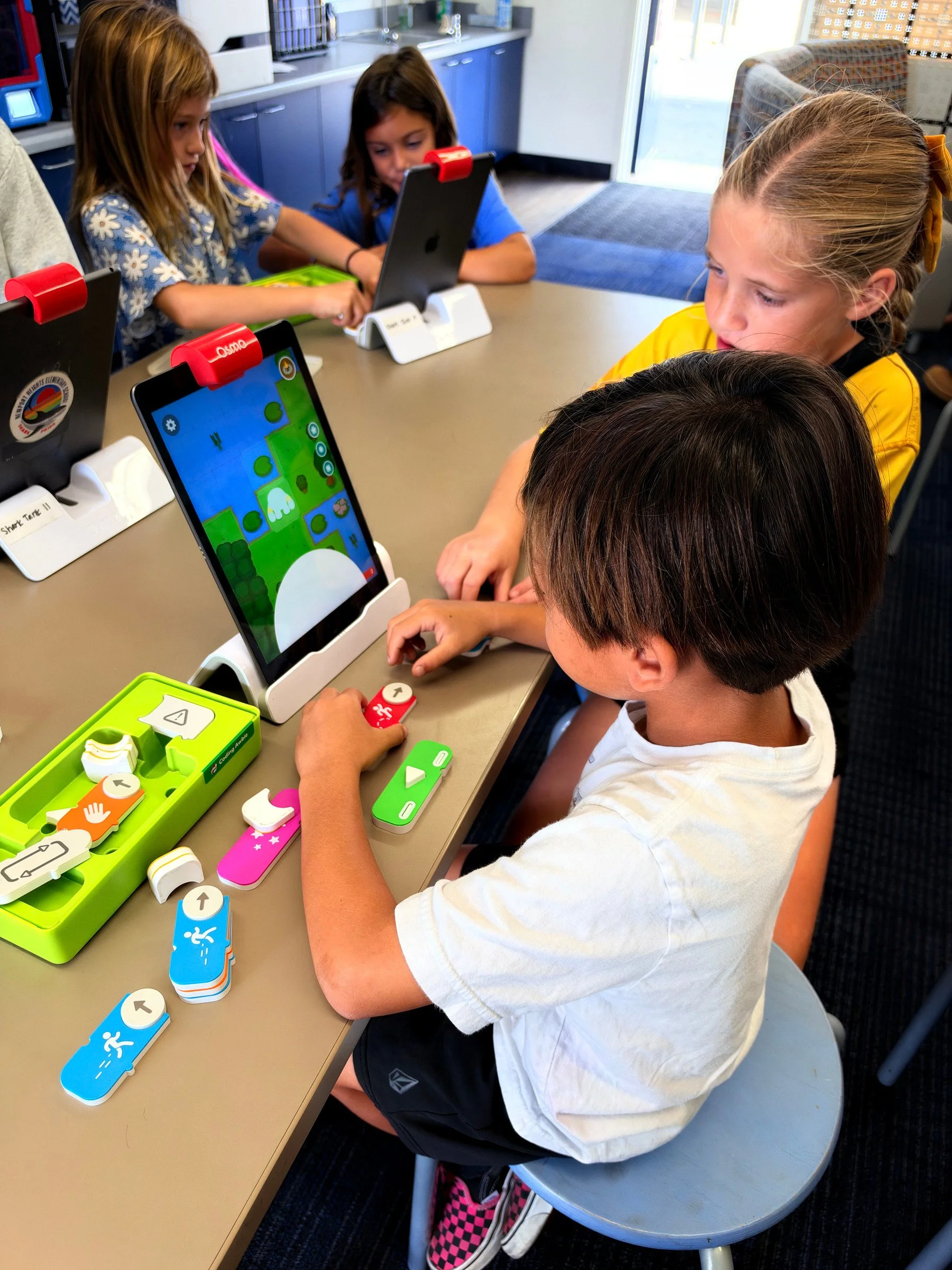 Students use iPads and hands-on Osmo coding pieces in the Shark Tank.