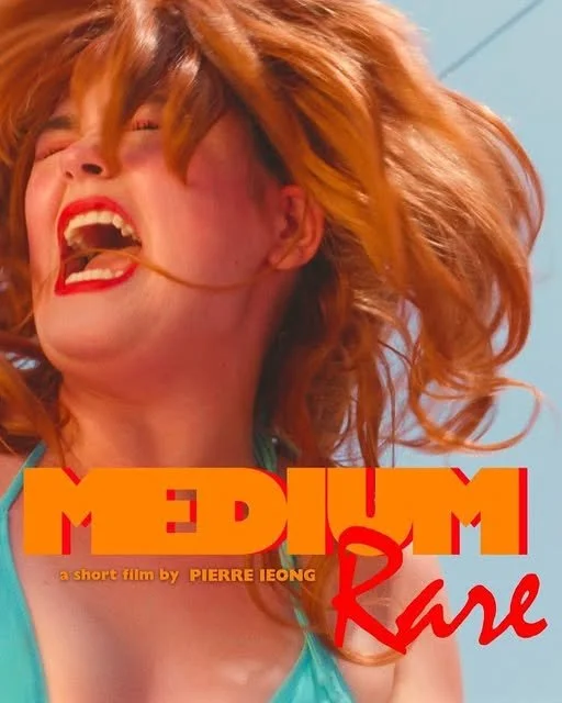 Close-up of a woman with red hair laughing, wearing red lipstick, with the title 'Medium Rare' in bold yellow and red letters, and smaller text indicating it's a short film by Pierre Ieong.