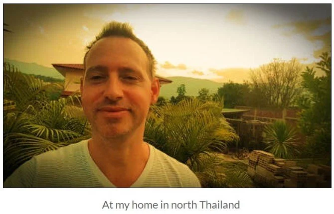 Chris Zanetti at his home in northern Thailand, surrounded by tropical plants and mountain views at sunset.