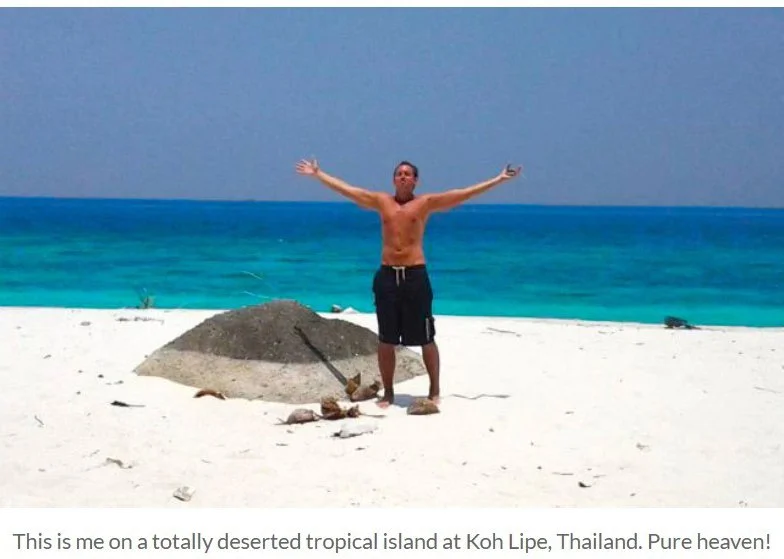 Chris Zanetti standing with arms outstretched on a deserted white-sand beach at Koh Lipe, Thailand.