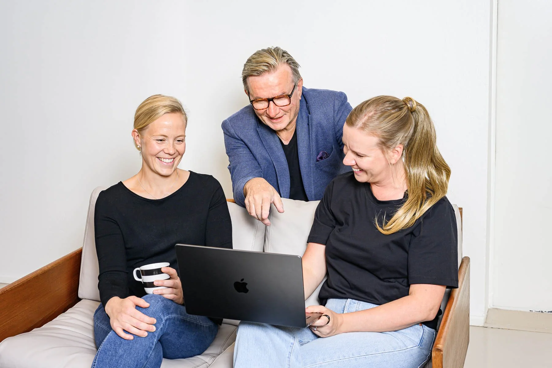 Helsinki Sales Academyn henkilöt katsovat tietokonetta ja nauravat.