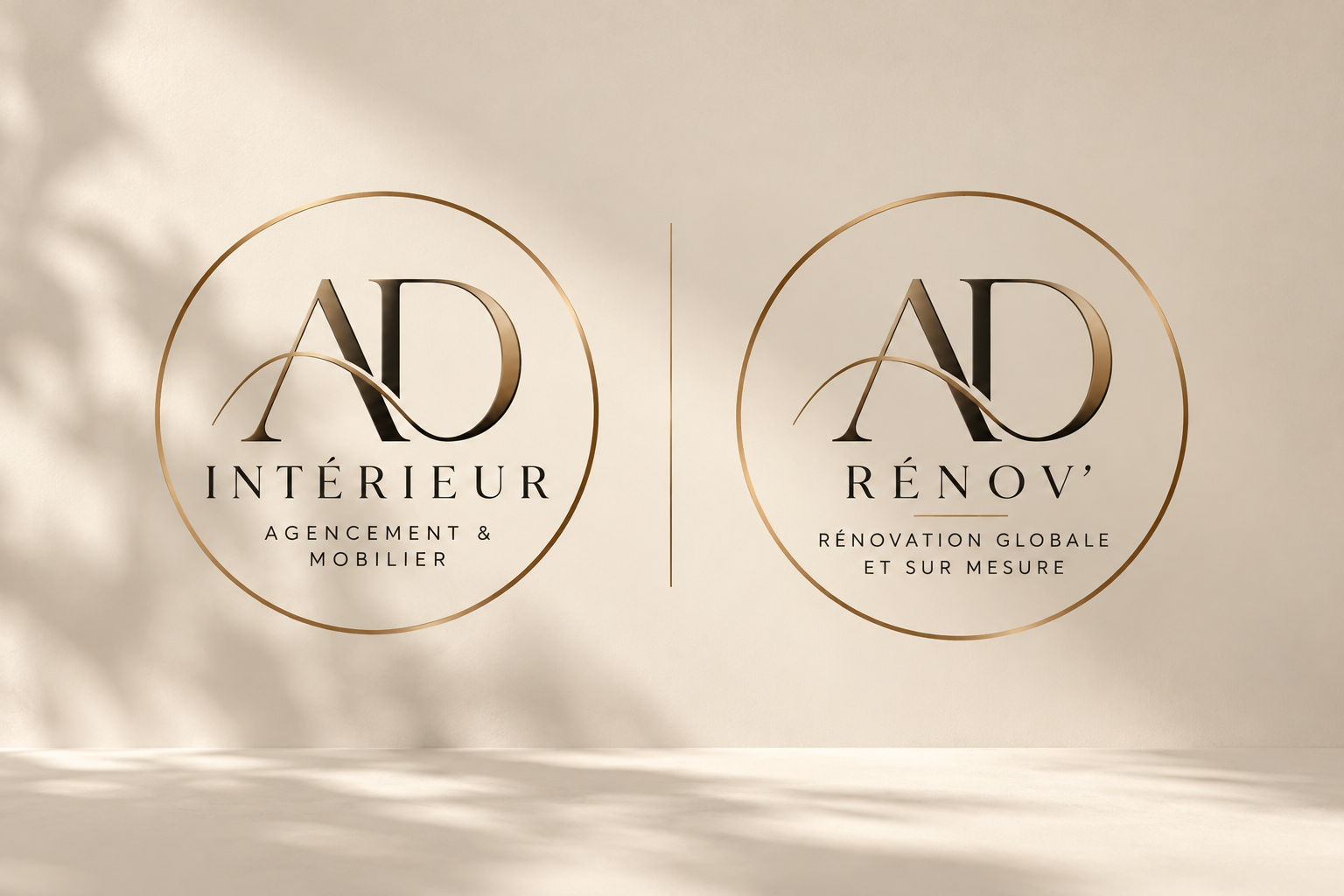 Deux logos ronds côte à côte, le logo de gauche dit 'AD Intérieur Agencement & Mobilier' et celui de droite 'AD Rénov Rénovation globale et sur mesure', sur un fond beige avec un éclairage doux.