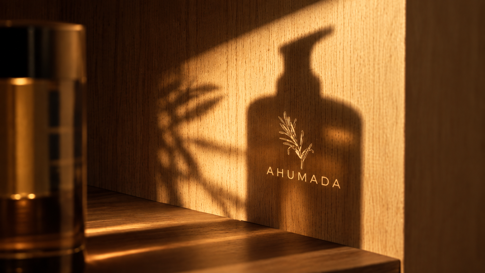Wooden surface with a shadow of a bottle and plant illustration, and the words "AHUMADA" on the wall.