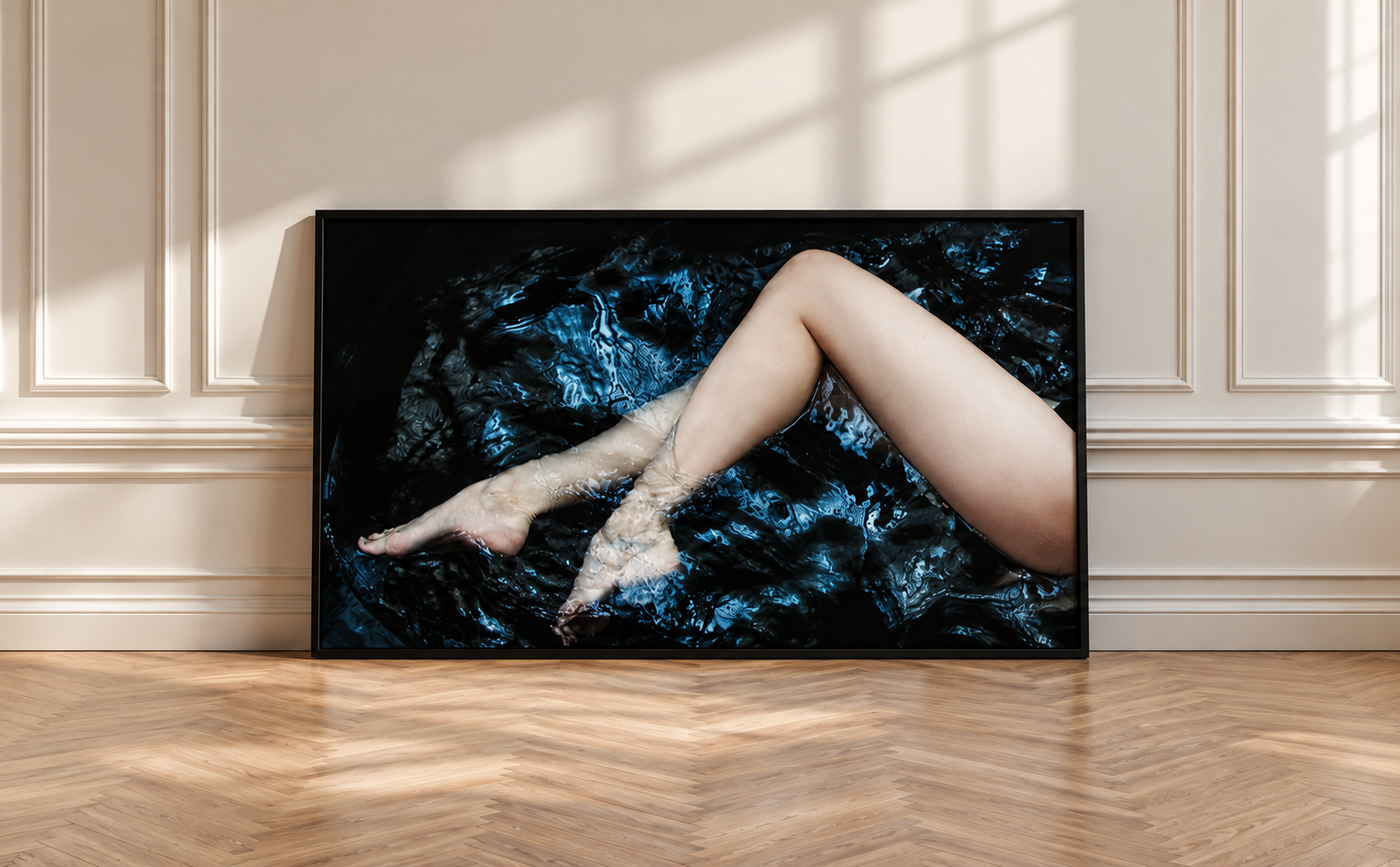 Framed boudoir wall art of legs in dark water, displayed in a sunlit room