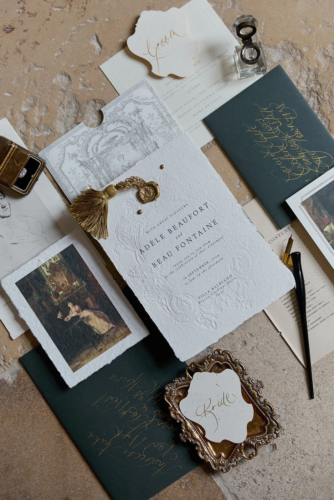 Hochzeitsvorbereitungen mit Einladungskarten, Gastgeschenken, Briefmarken, Notizen und Dekorationen in Gold und Weiß auf einem Tisch.