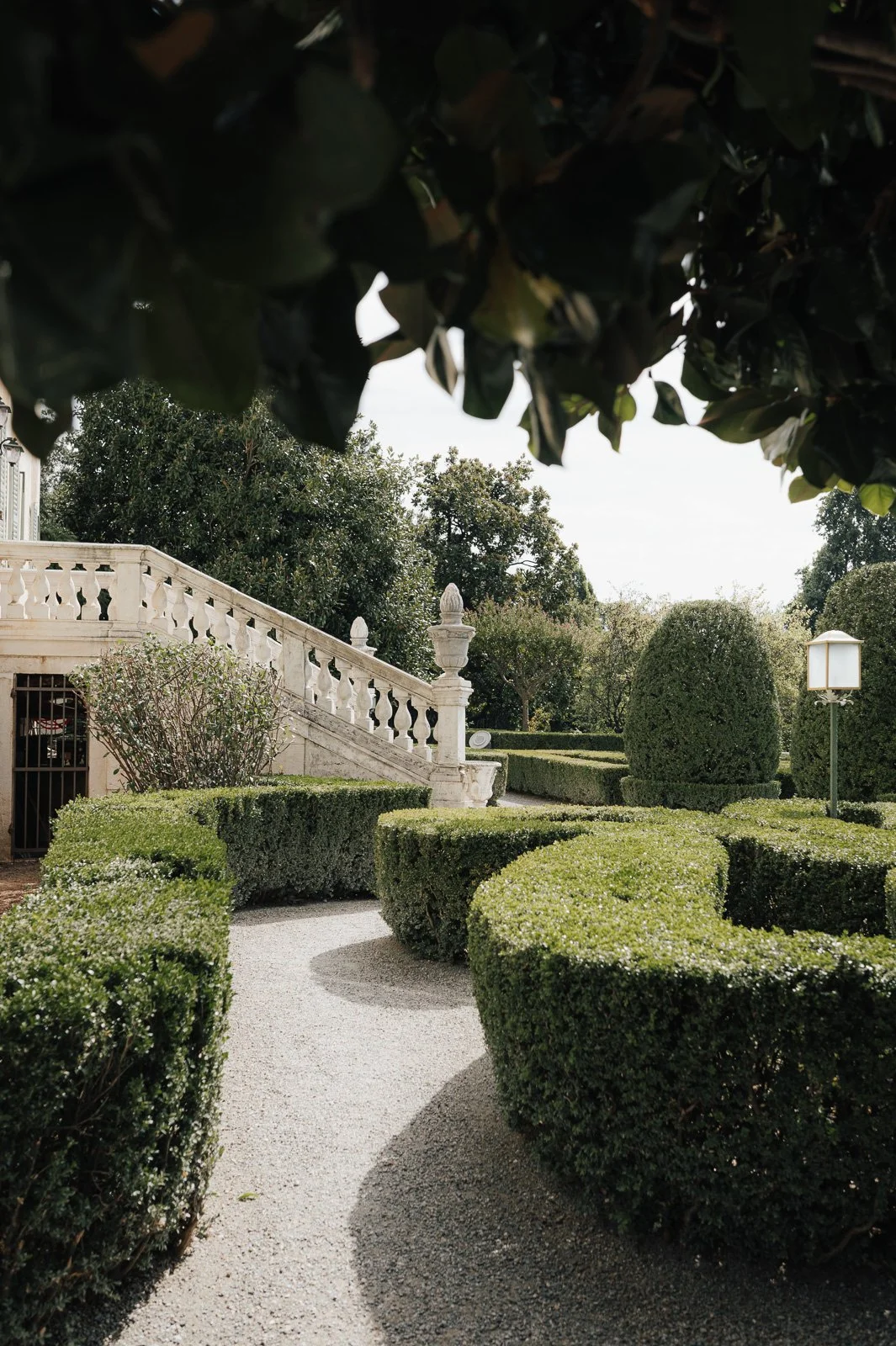 Garten mit gepflegten Buchstabenförmigen Hecken, Steinstufen und Laterne