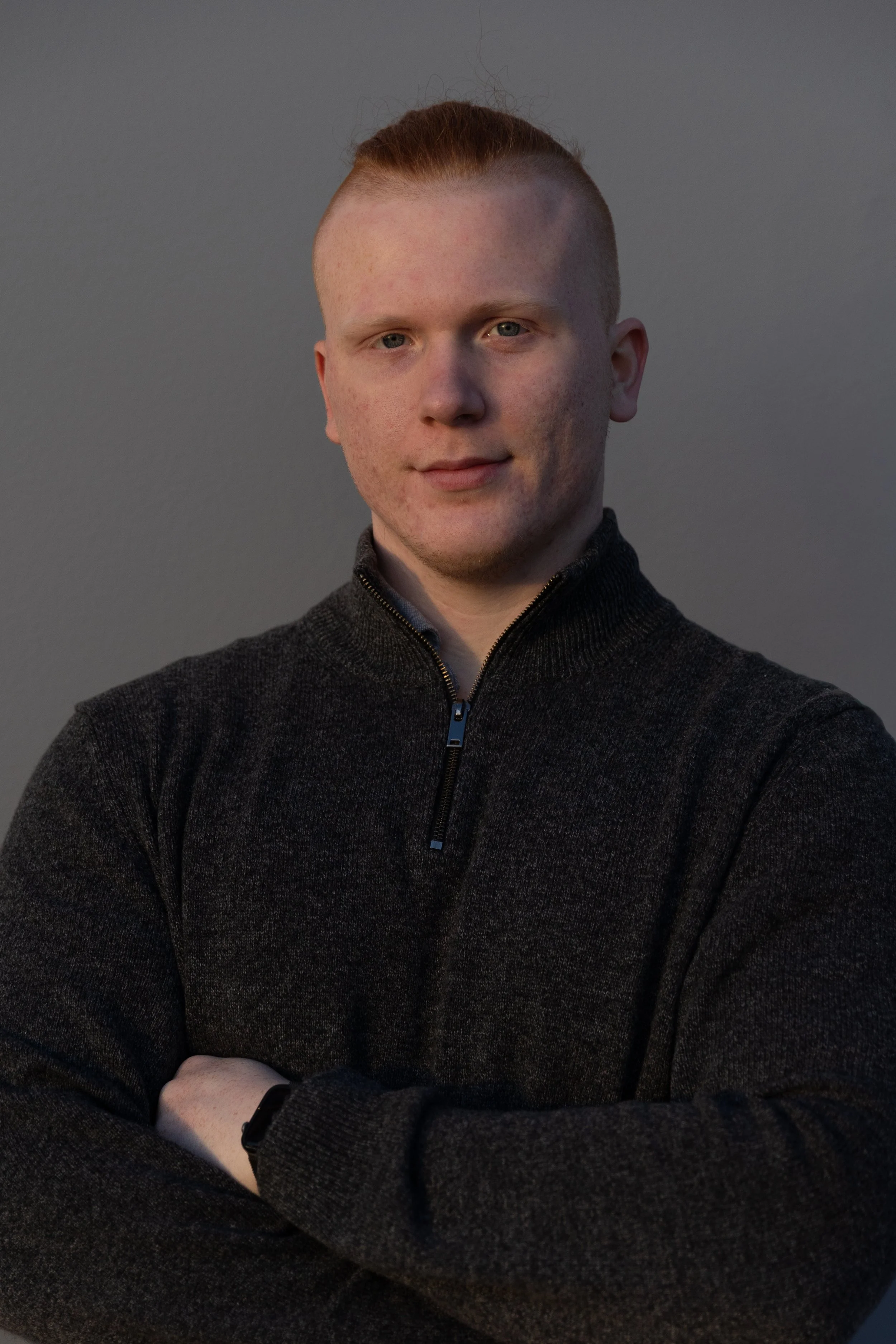 Junger Mann mit grauem Pullover