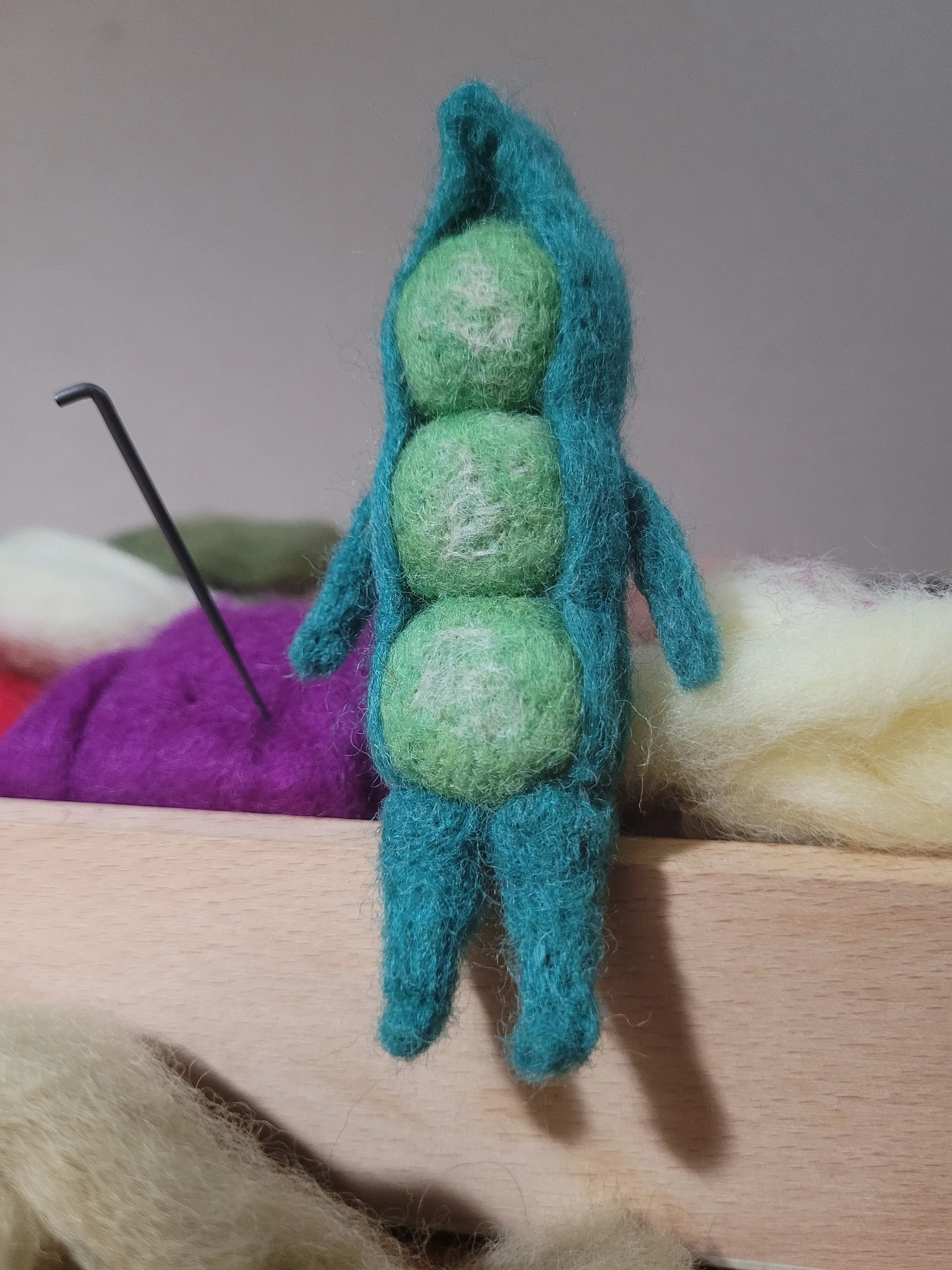 A felted pea pod creature