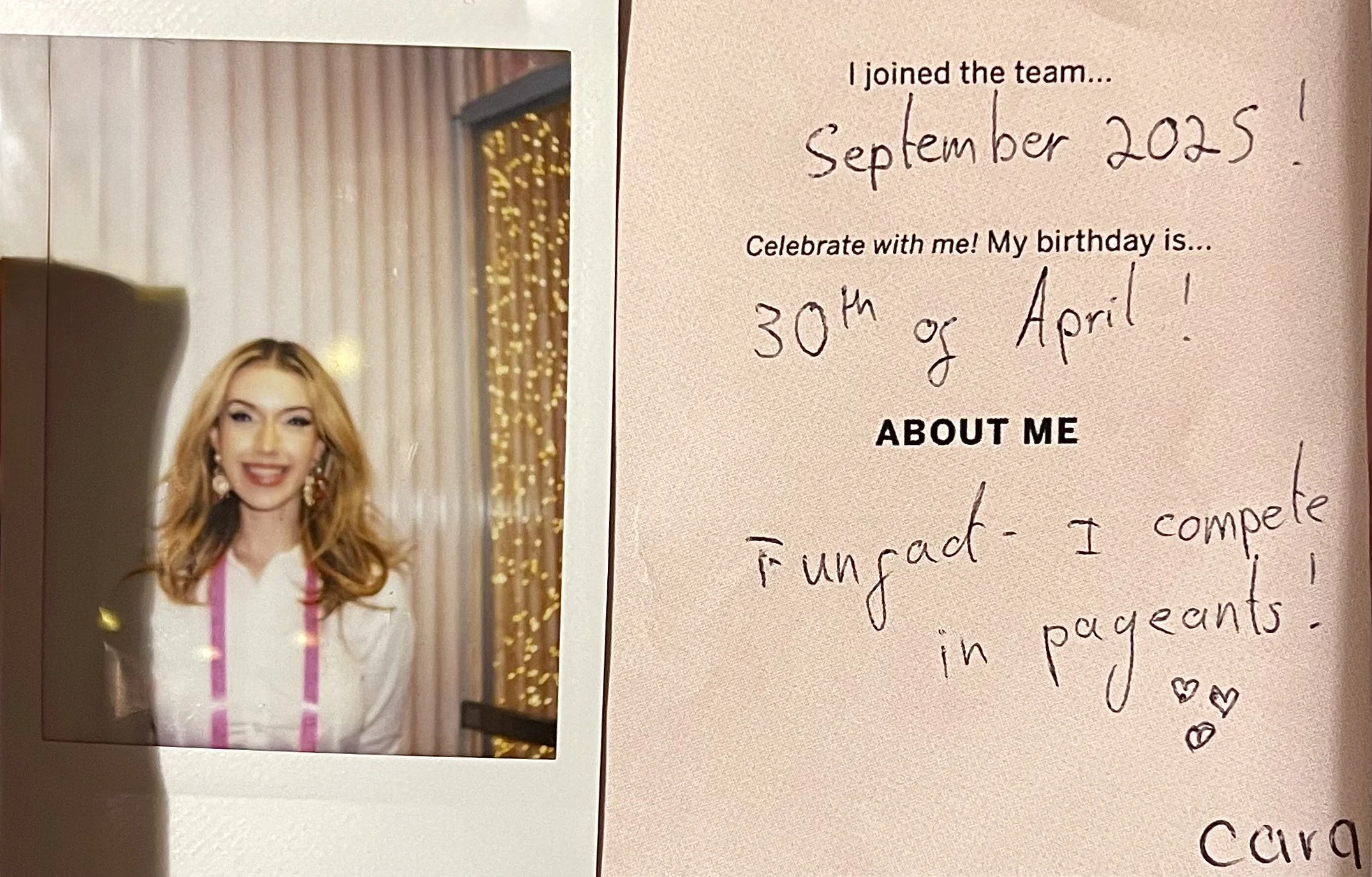 A woman with blonde hair, wearing earrings and a white top, smiling in front of a curtain with string lights. To the right, a handwritten note on pink paper reads, "I joined the team... September 2025! Celebrate with me! My birthday is... 30th or April!"