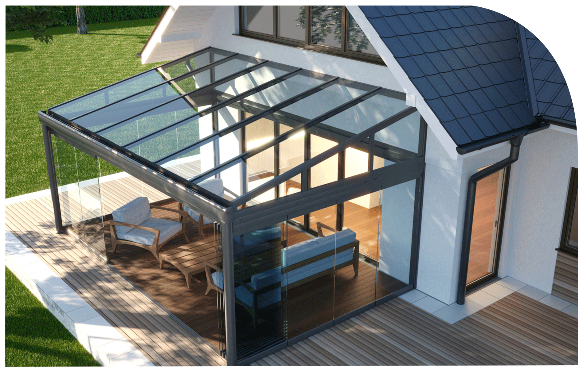 A modern house with a glass sunroom attached, featuring chairs and a sofa on the wooden deck, surrounded by green grass and trees.