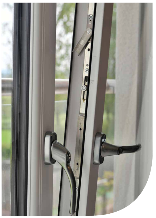 A close-up of a window handle and lock mechanism, with the window partially open and a blurred background outside.
