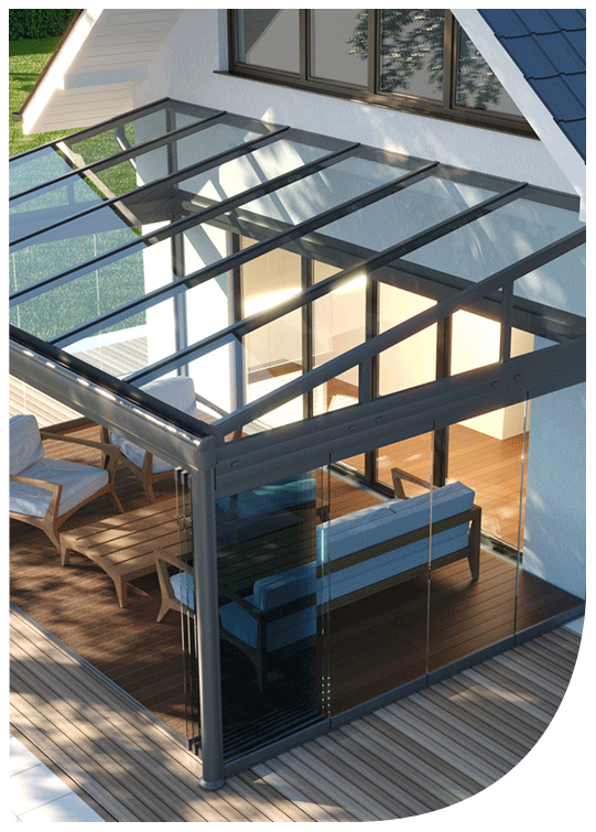 View of a glass-enclosed outdoor patio with wooden flooring, furniture including a sofa and chairs, and a metal-framed glass roof.