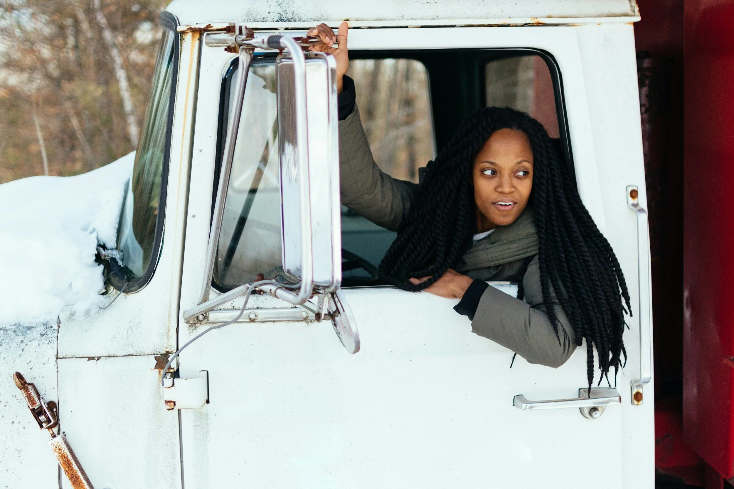 Truck driver smiling from the window of her cab