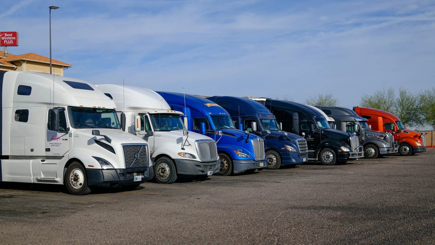 A row of semi trucks parked at a terminal