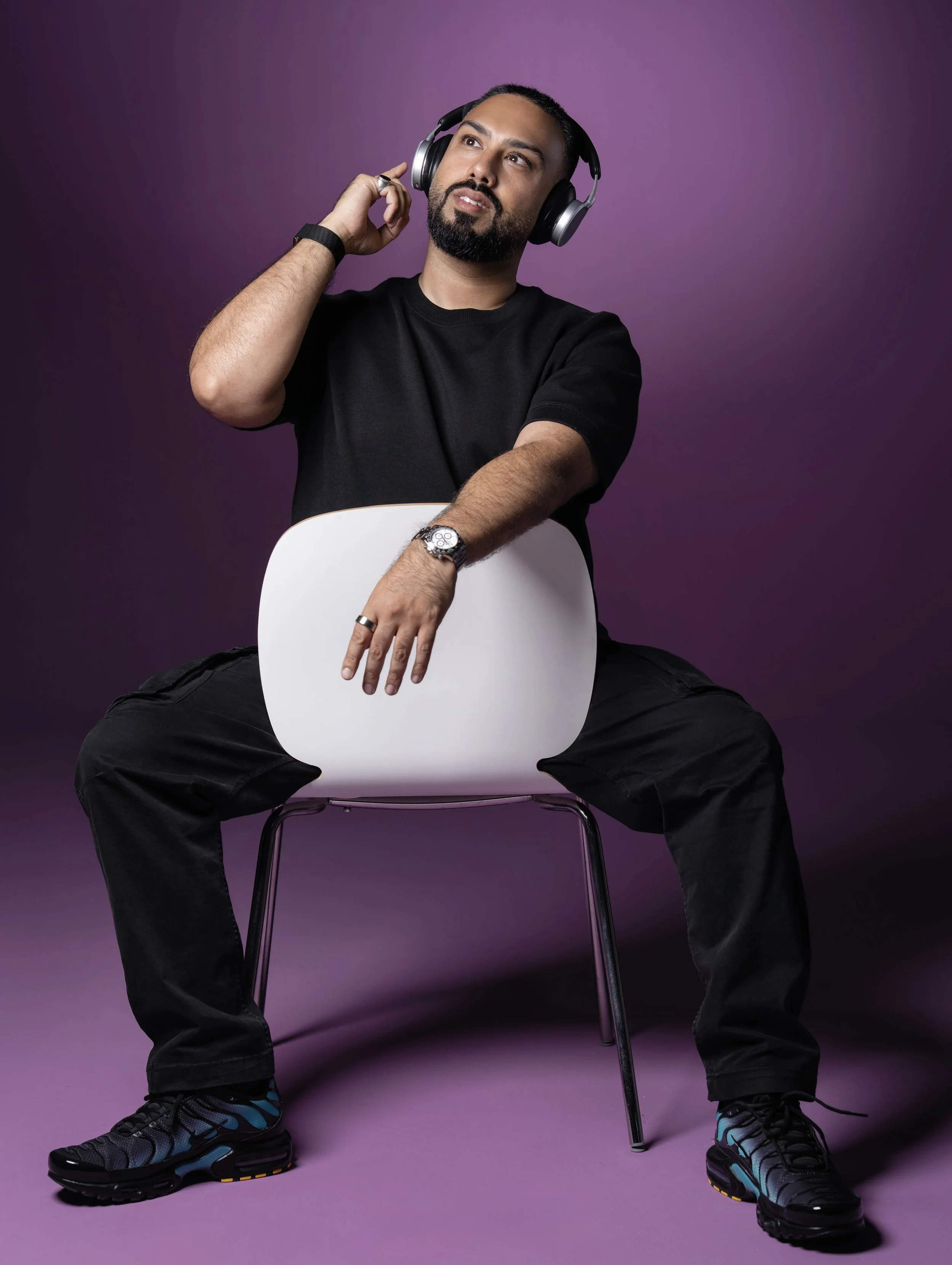 Headphones / seated portrait
    EMKWAN seated with headphones during a technology and media production session.
