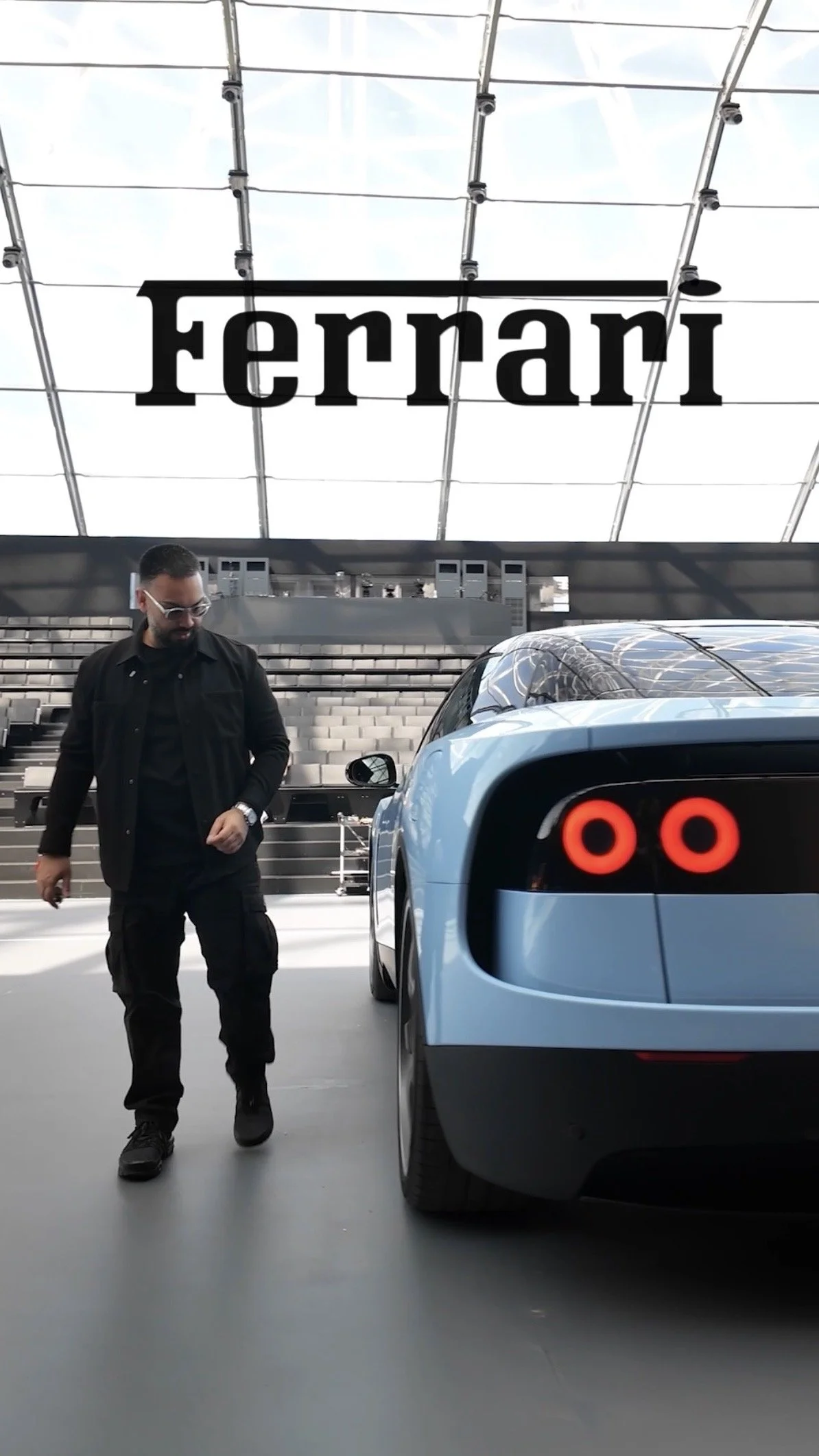 Ferrari image
    EMKWAN walking past a blue Ferrari Luce  during an automotive technology event.