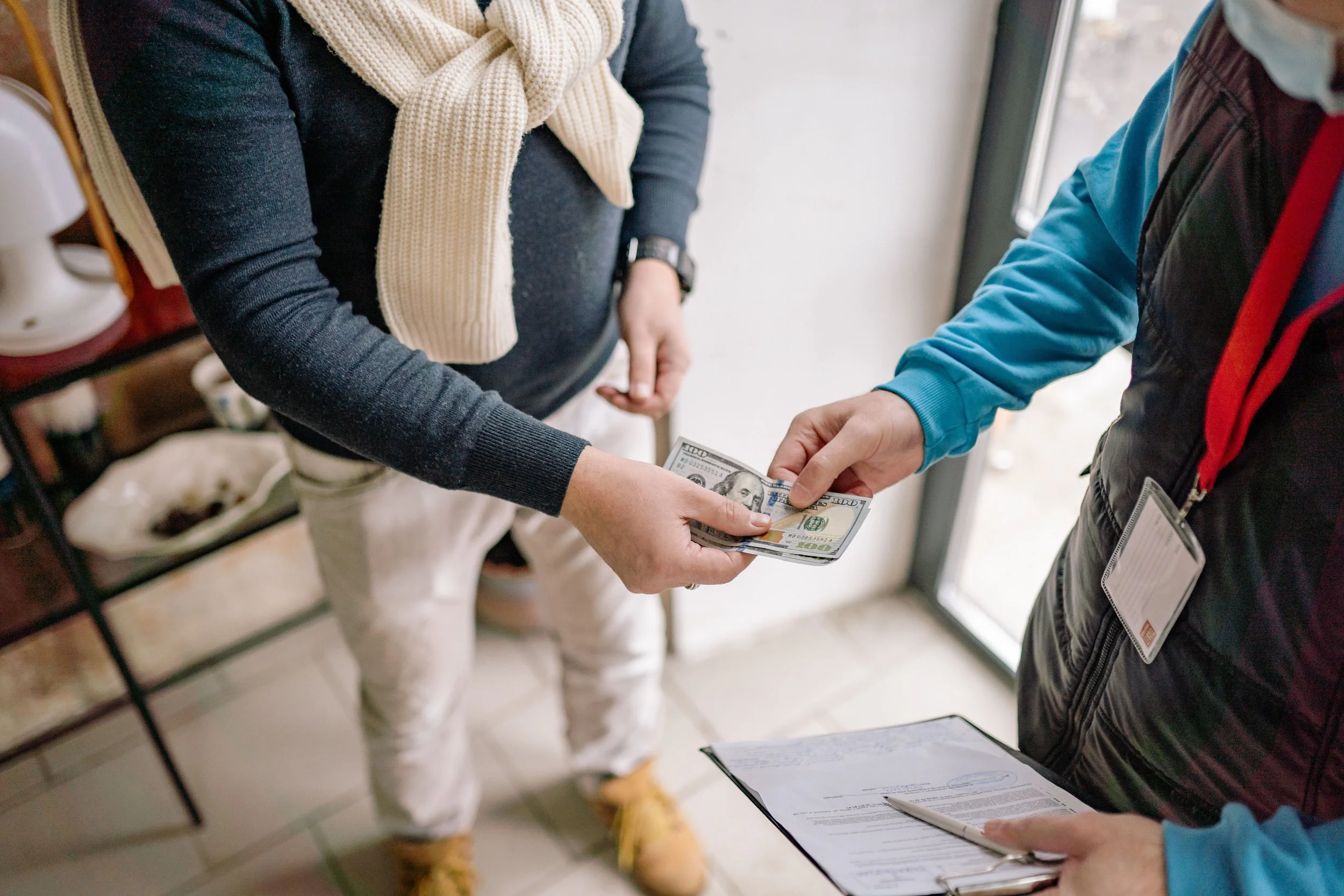 Customer paying a service provider with U.S. cash during an in-person transaction, representing commerce, small business services, customer transactions, local business operations, and payment processing.