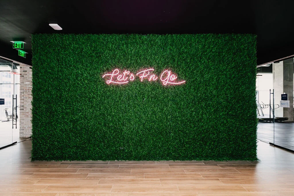 Greenwall with a neon sign set into the foliage