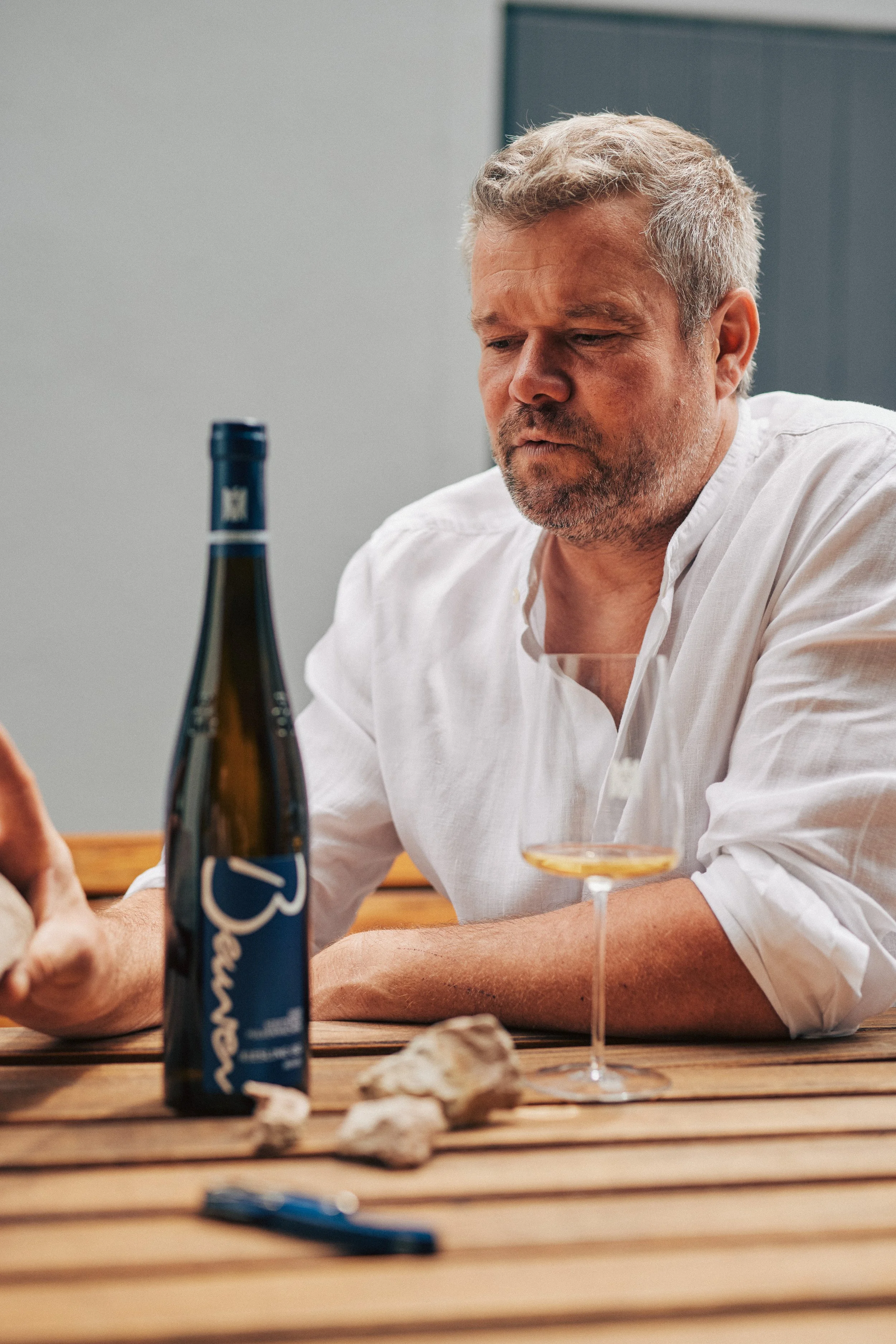 Winzer am Tisch mit einer Flasche vom Weingut Beurer
