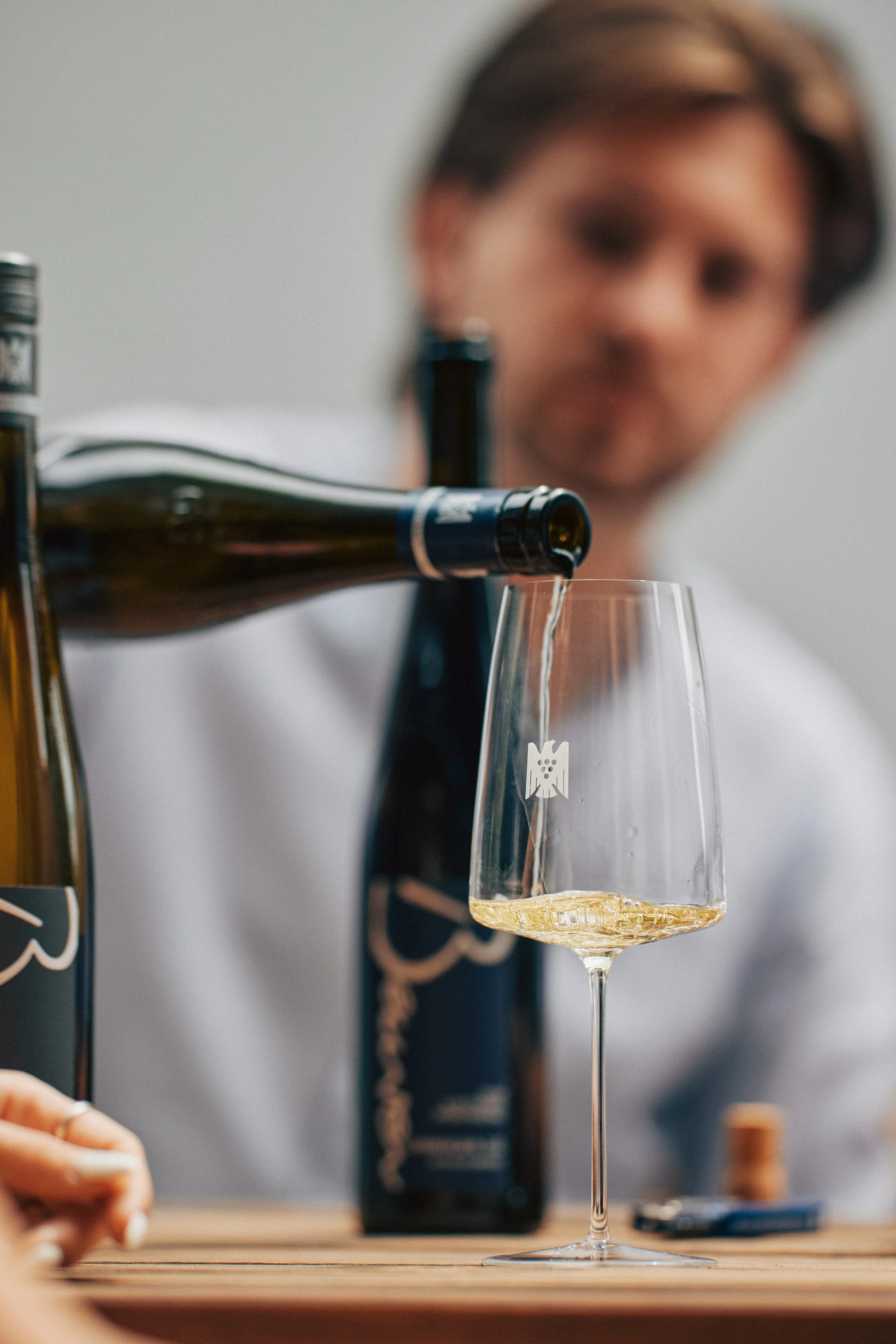Weißwein wird in der Vinothek ins Glas eingeschenkt