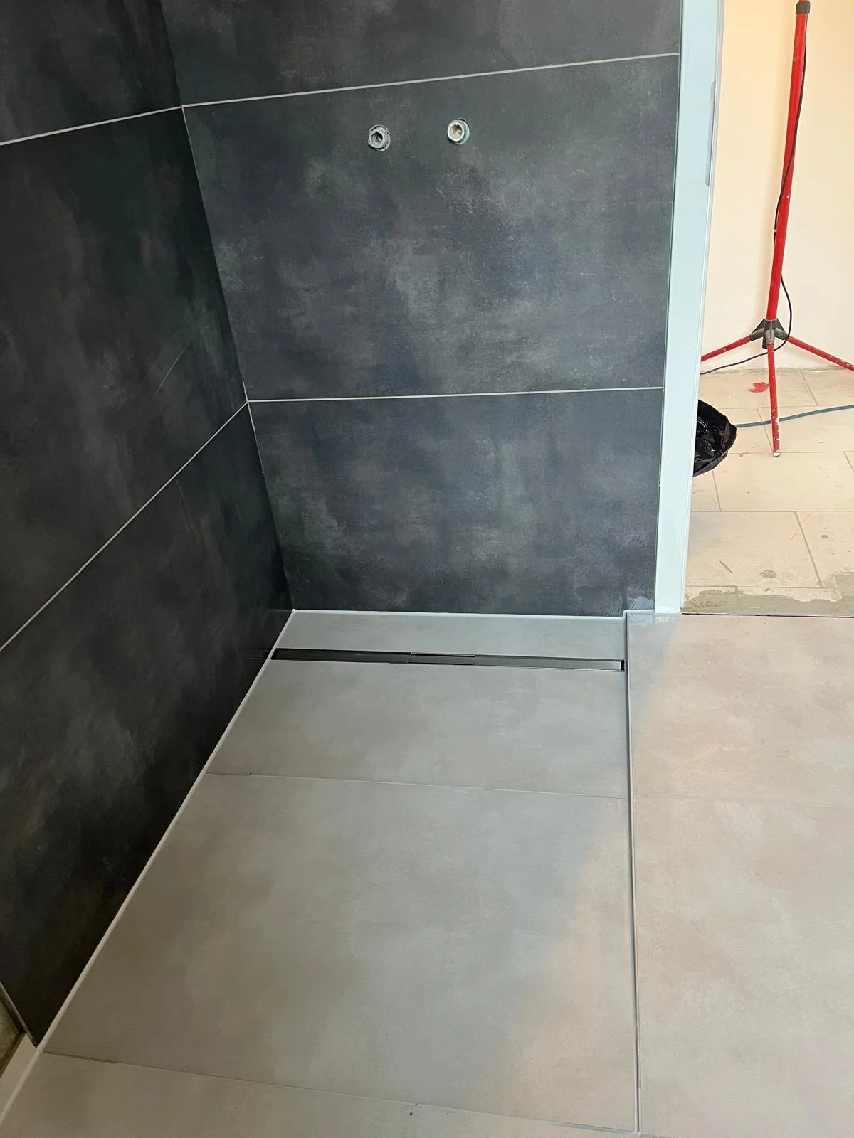 Duschbereich mit Duschrinne und anthrazitfarbenen Wandfliesen
