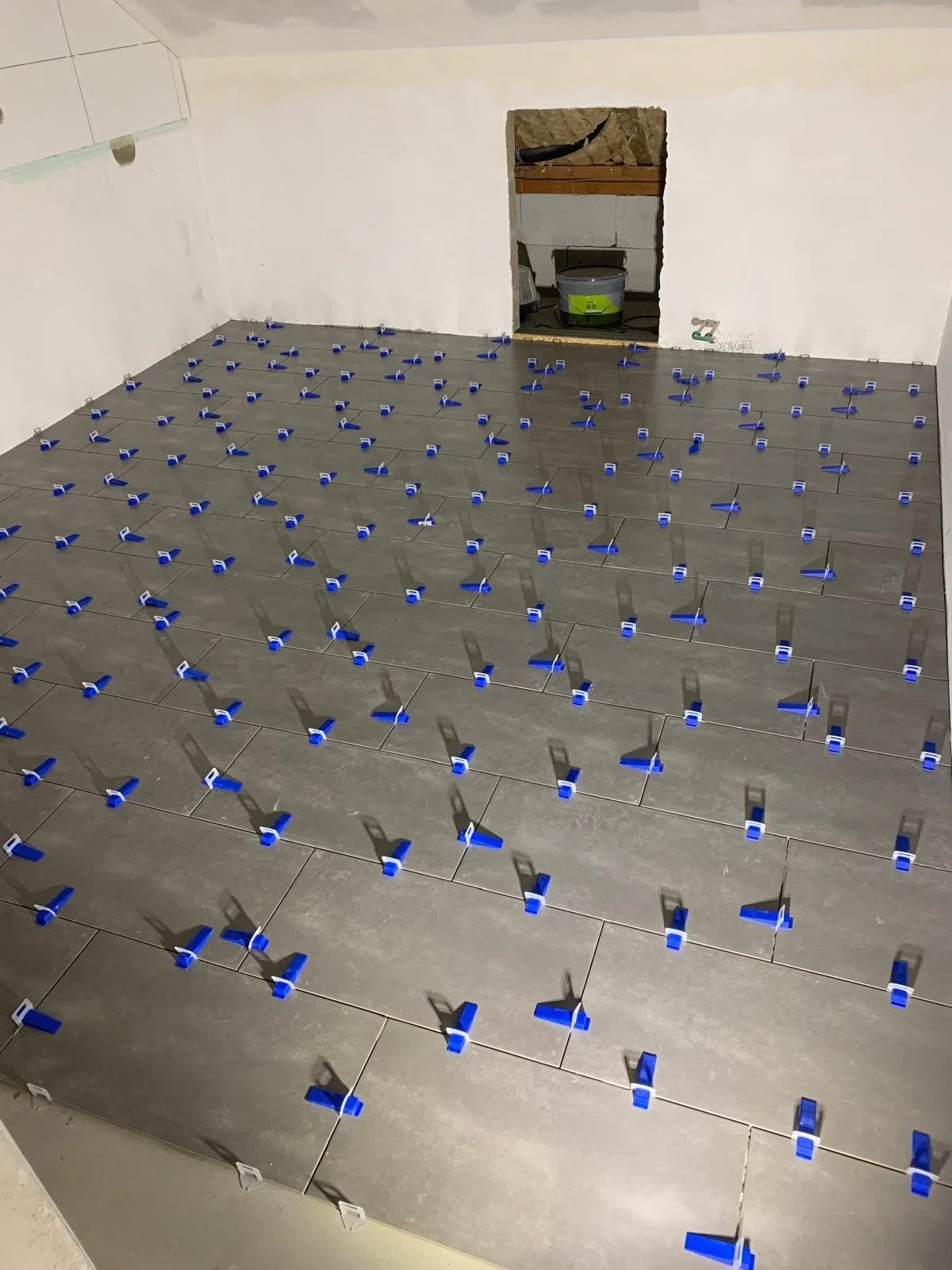 Verlegung großformatiger Bodenfliesen mit Nivelliersystem für eine ebene Fläche