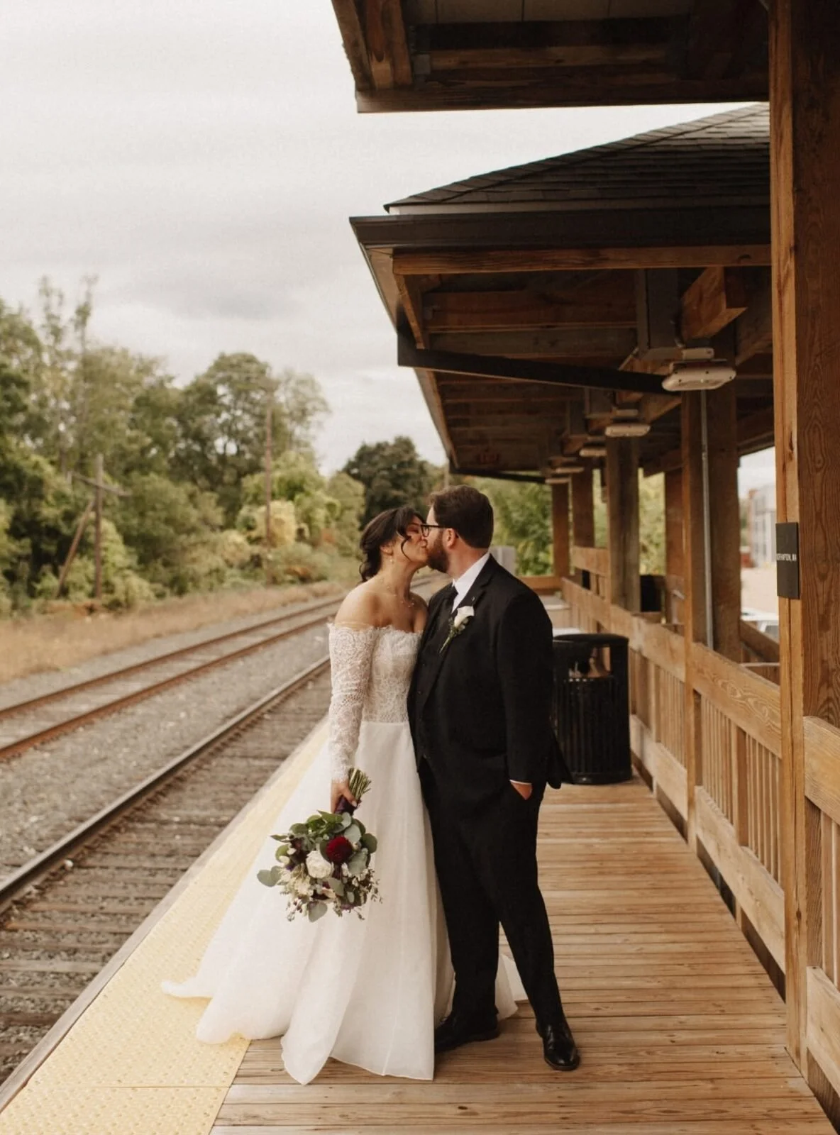 Bride and groom kissing on the train platform at Union Station Banquets, Northampton MA