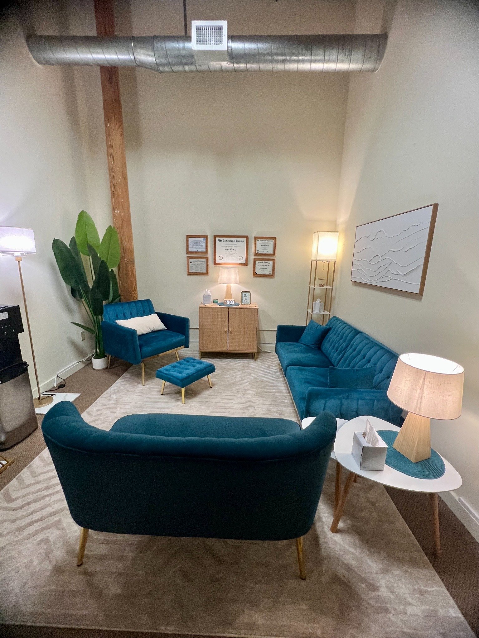 Dr. Michelle Kanga’s therapy office at Fort Andross in Brunswick, Maine, with blue seating and warm lighting.