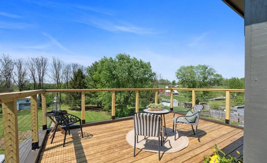 Rooftop deck with cable railing and new decking, built for open views of the countryside.