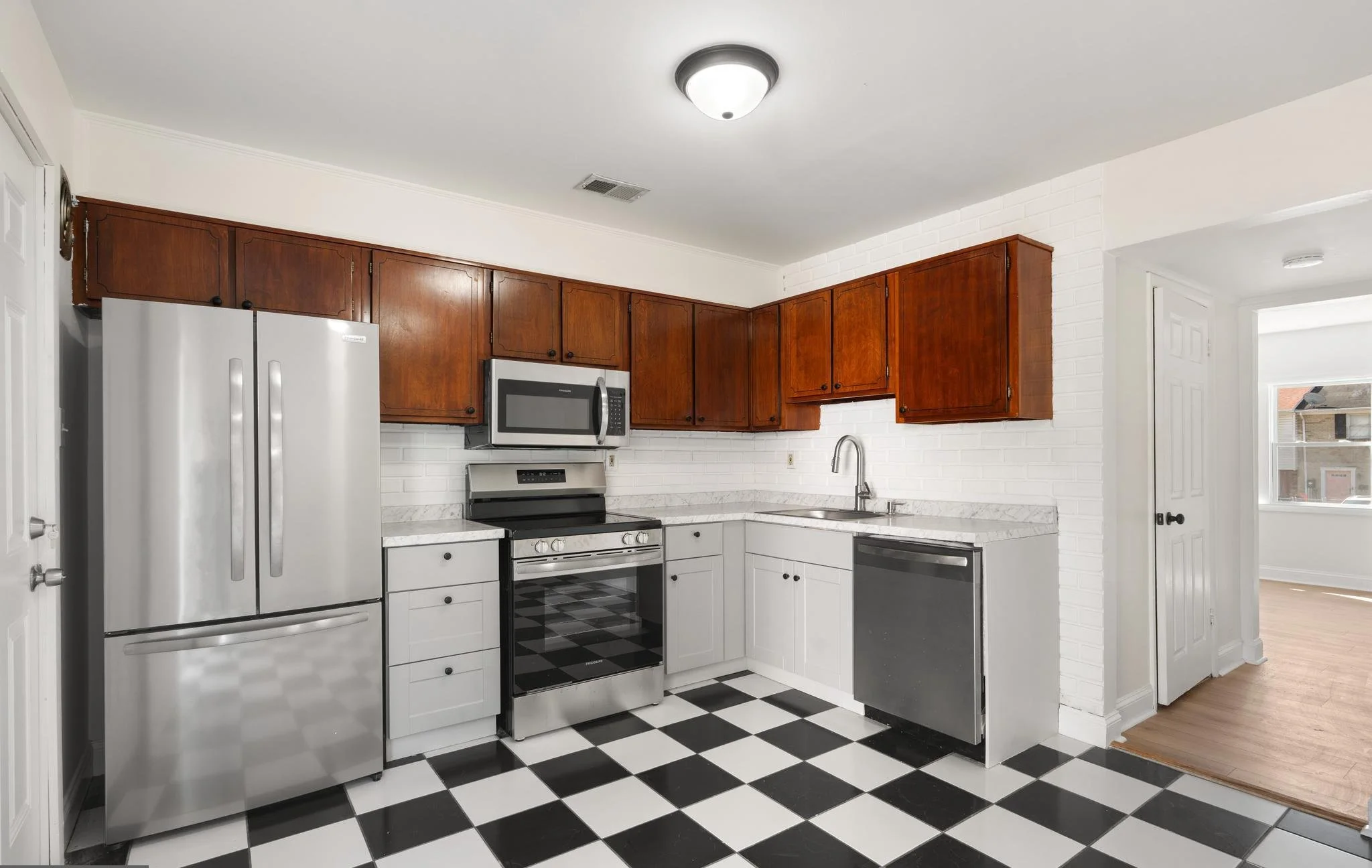 Kitchen refresh with new cabinets and countertops, turning a tired kitchen into a bright, practical space.