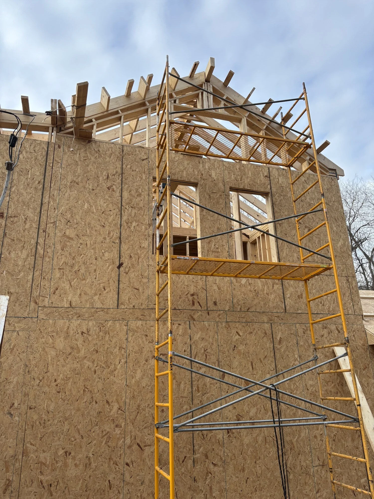 Sheathing a newly framed house, closing in the structure and getting it ready for wrap, windows and siding.
