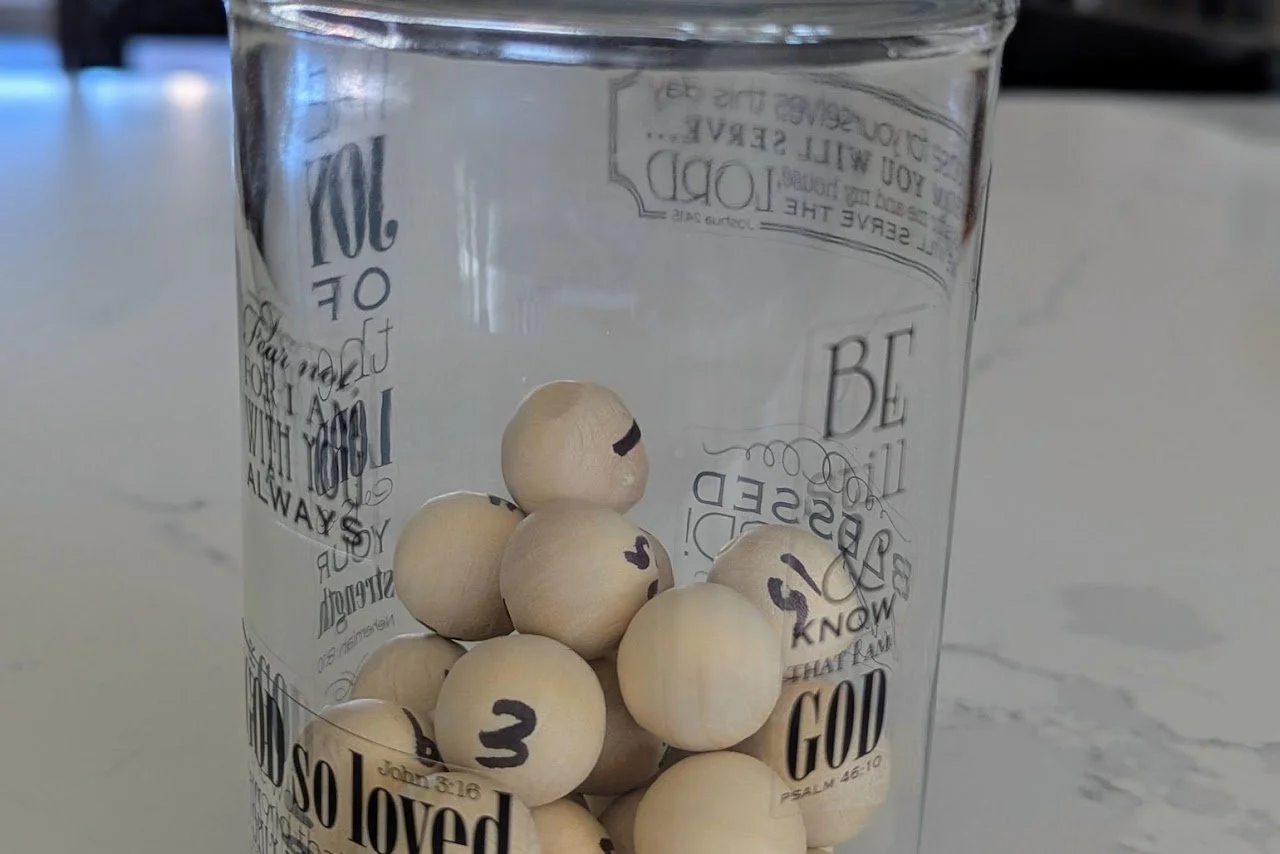 Darrin’s glass jar of numbered wooden balls, one for each year.