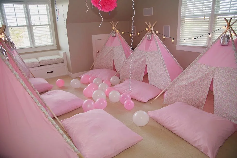 Pink paisley teepee tents glowing around a campfire-inspired centerpiece