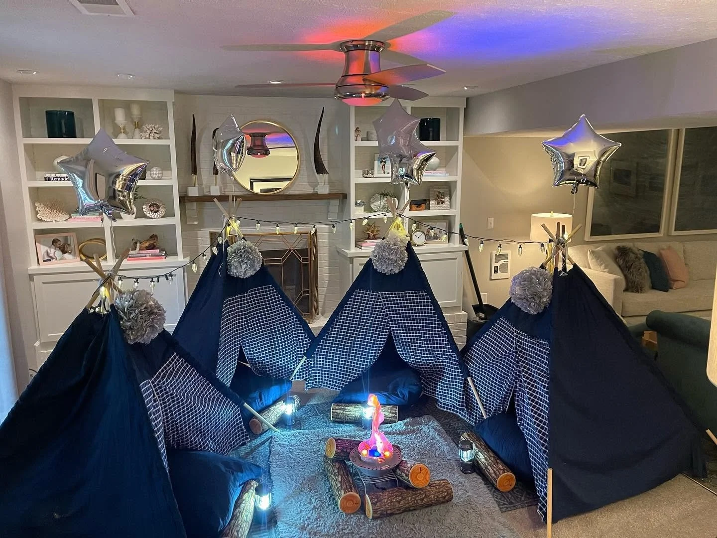 Navy plaid teepee tents glowing around a campfire-inspired centerpiece
