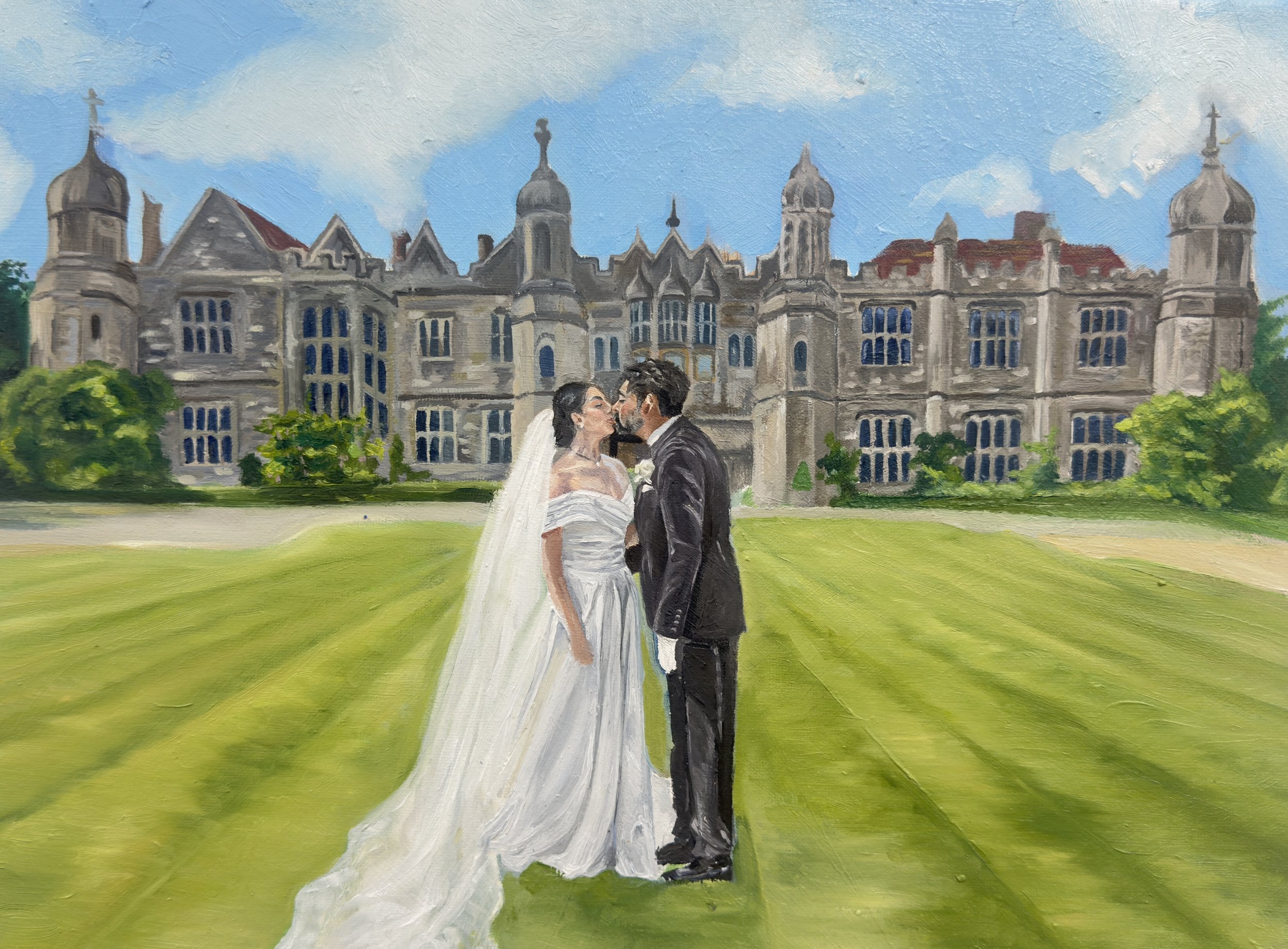 A bride and groom standing close and kissing in front of a large, historic castle with turrets under a partly cloudy sky, with lush green lawn surrounding them.